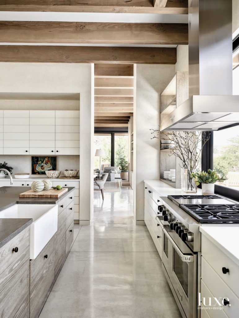 The layout combines a spacious work area with expansive views to the mountains," notes Biegner of the kitchen, where Miller combined polished concrete floors and countertops with a natural basalt island to a simple, sophisticated effect. A farmhouse sink by Julien with fixtures from Clyde Hardware apposes a Monark range.