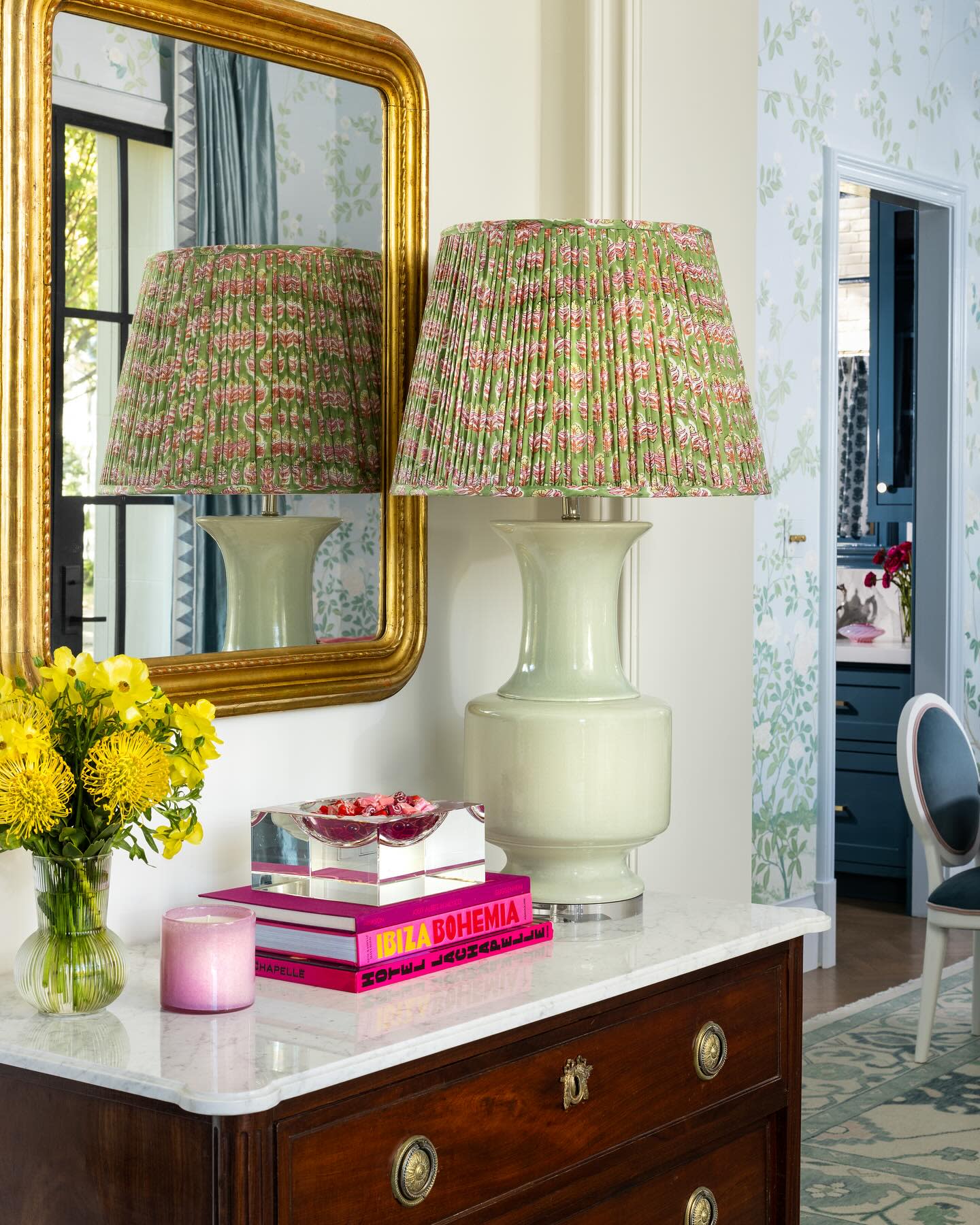 a table with a lamp and a vase of flowers