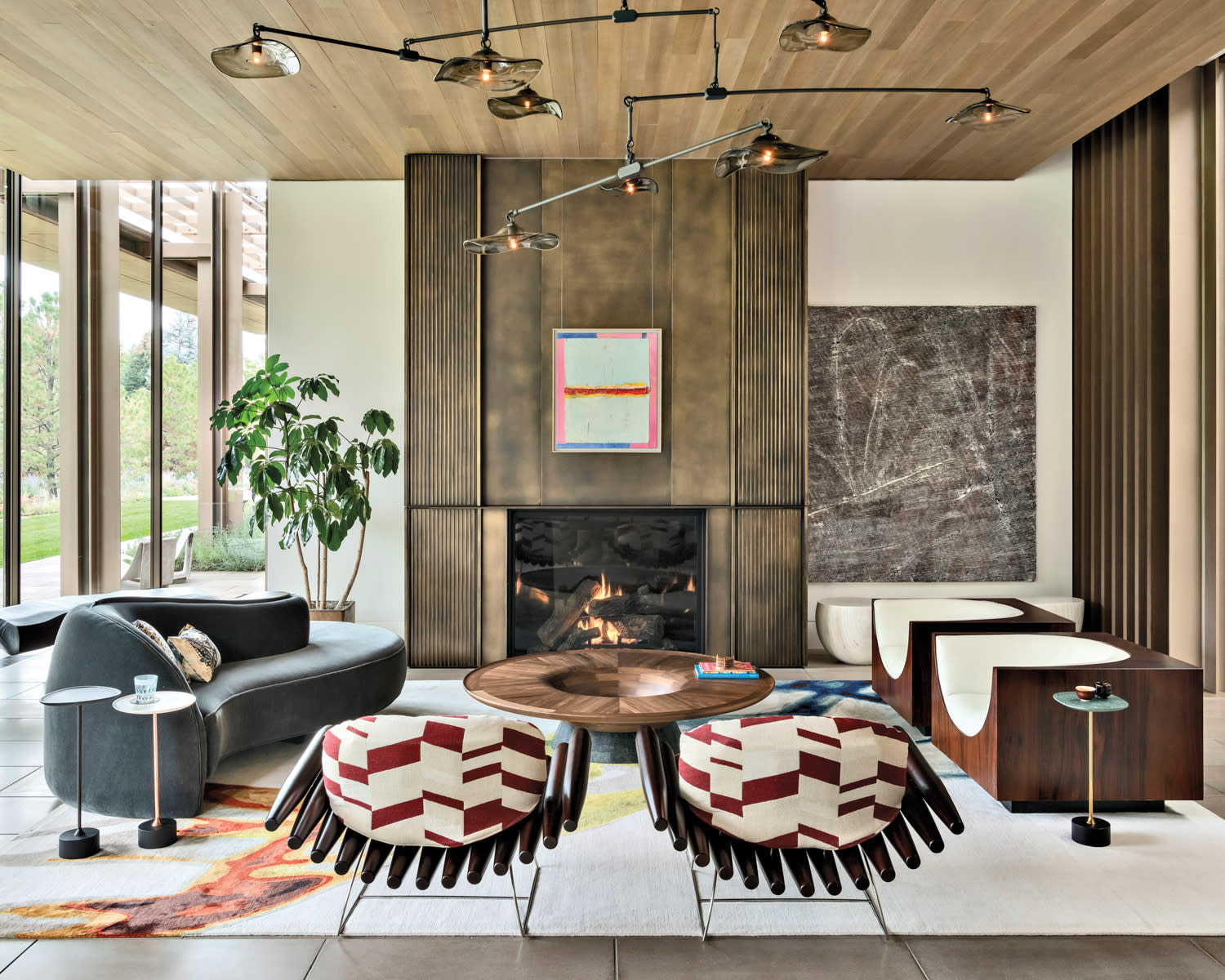 living room with bronze fireplace, sculptural chairs, curved sofa and round coffee table by Cecilia Tanoni