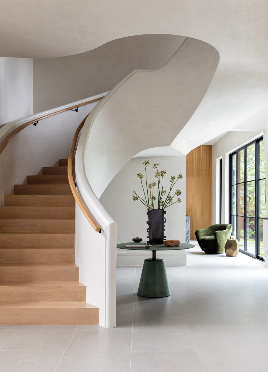 foyer with white plaster walls and light wood stairs