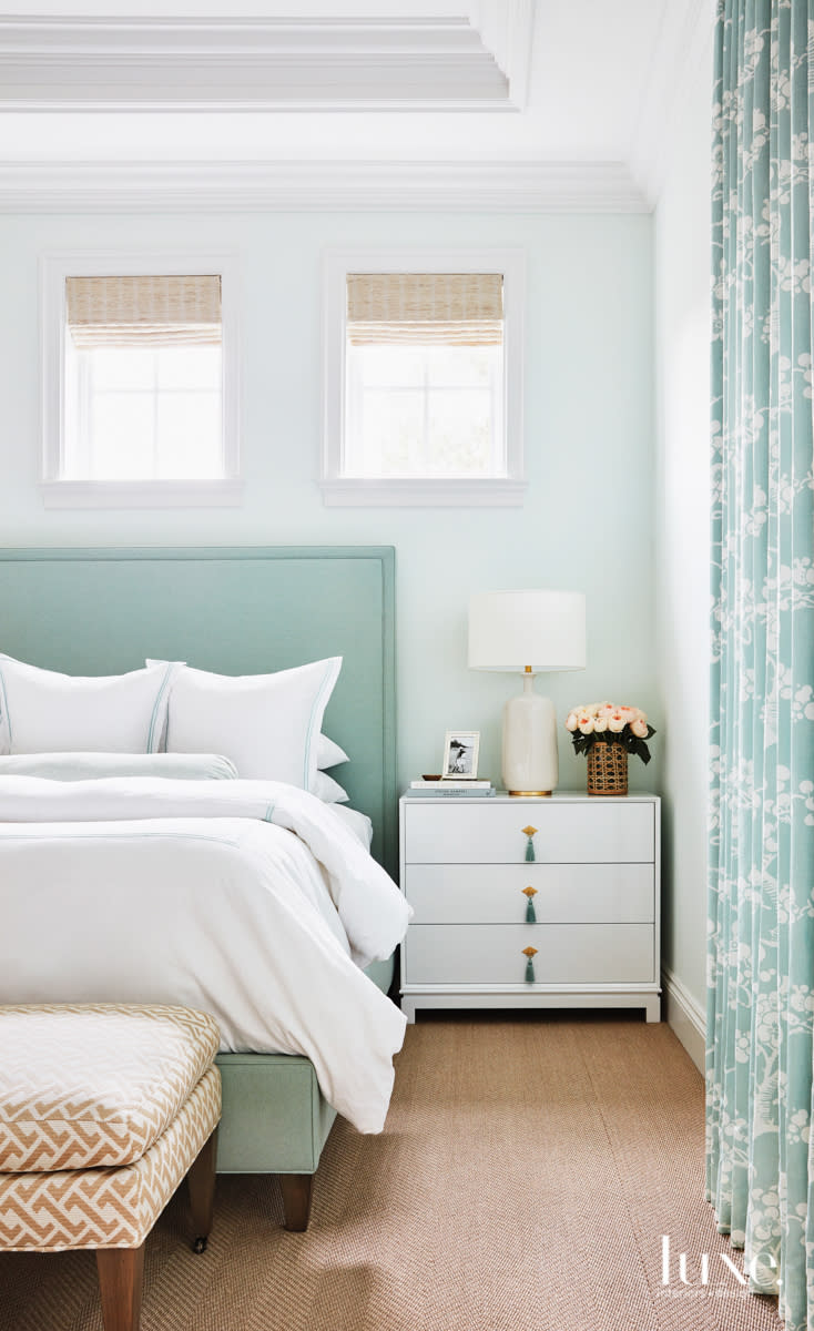 Bedroom with aqua bed and draperies, pale blue walls and white bedding and nightstand