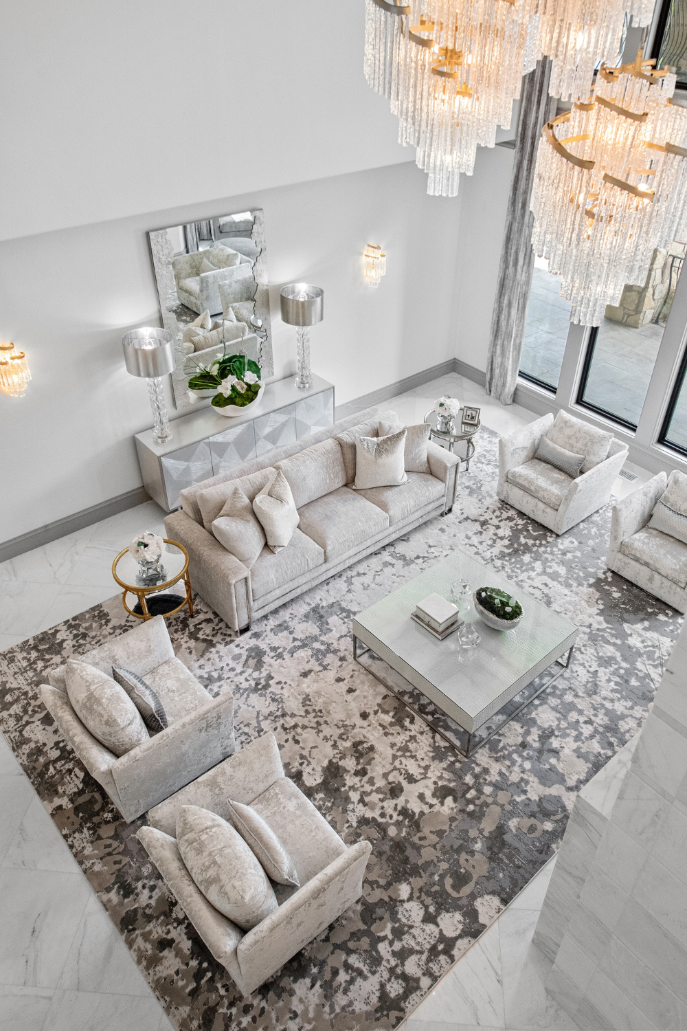 A stylish living room by Susan Semmelmann Interiors adorned with white furniture and a beautiful chandelier, creating a chic and inviting atmosphere. The Majestic Maze, Plano. 