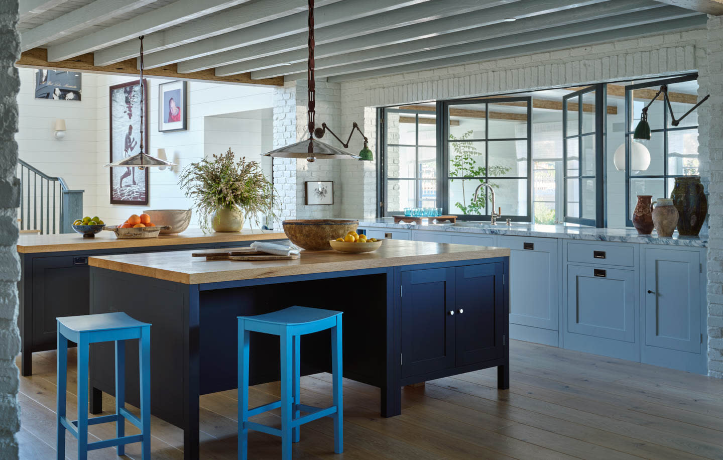 classic kitchen with a dark blue island and light blue barstools
