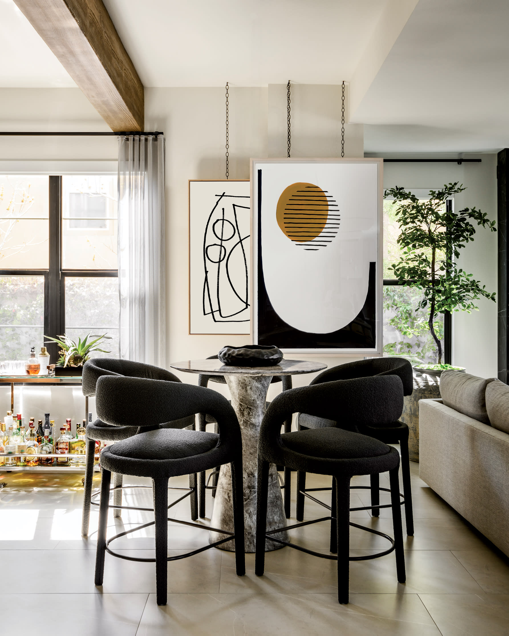 dining area with midcentury style dining chairs and modern minimalist artwork 