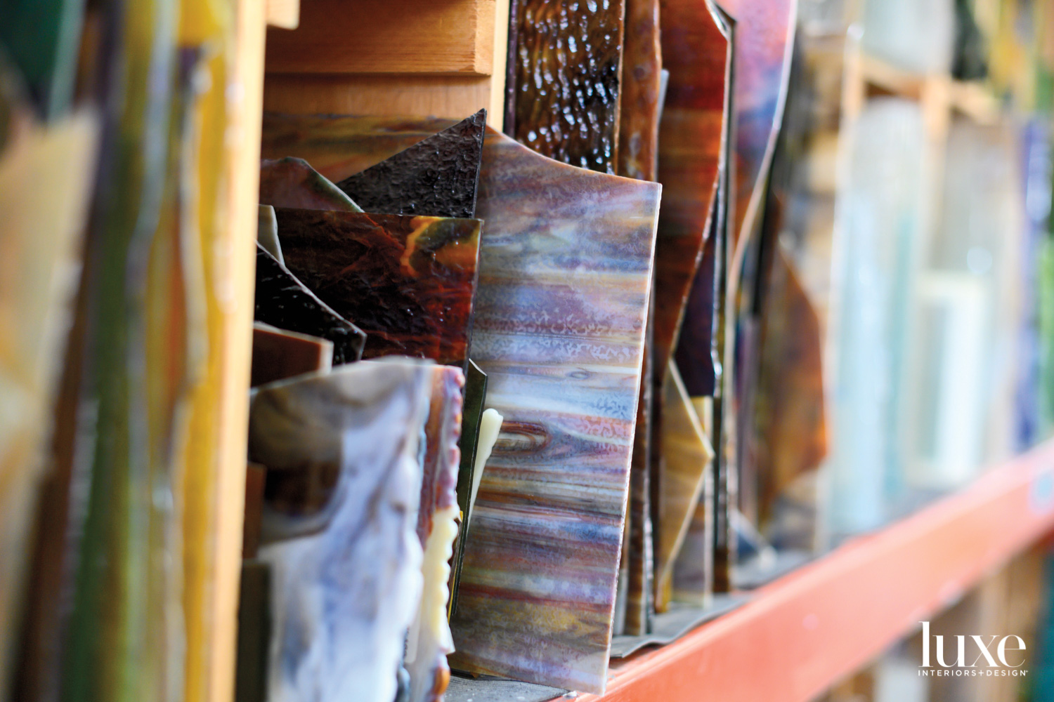 Sheets of stained glass are stored on shelves in the studio.