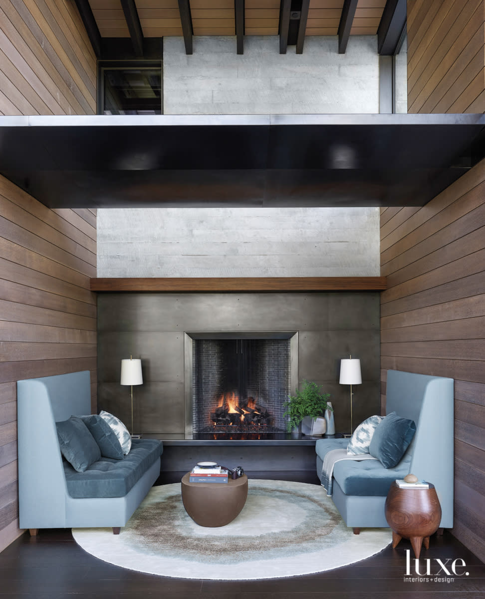 nook with a fireplace and blue high back couches