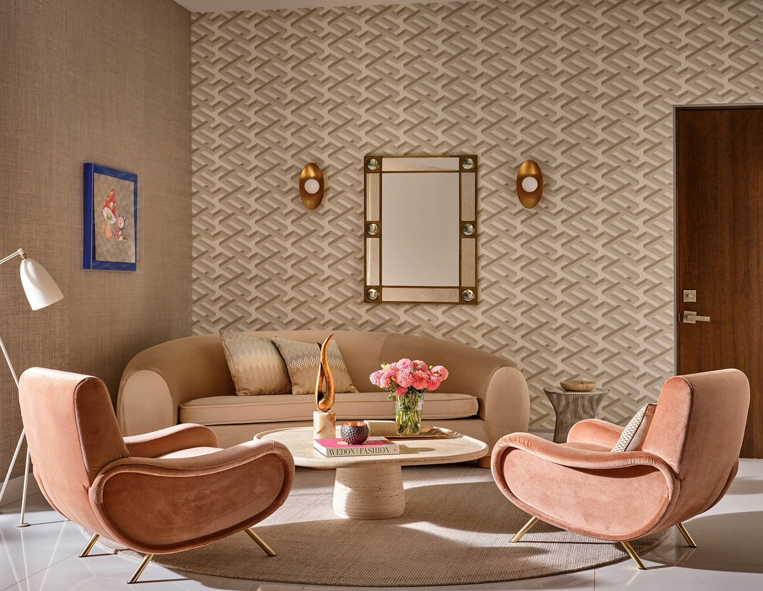 A bedroom sitting area with geometric wallpaper and a light-colored couch in a corner