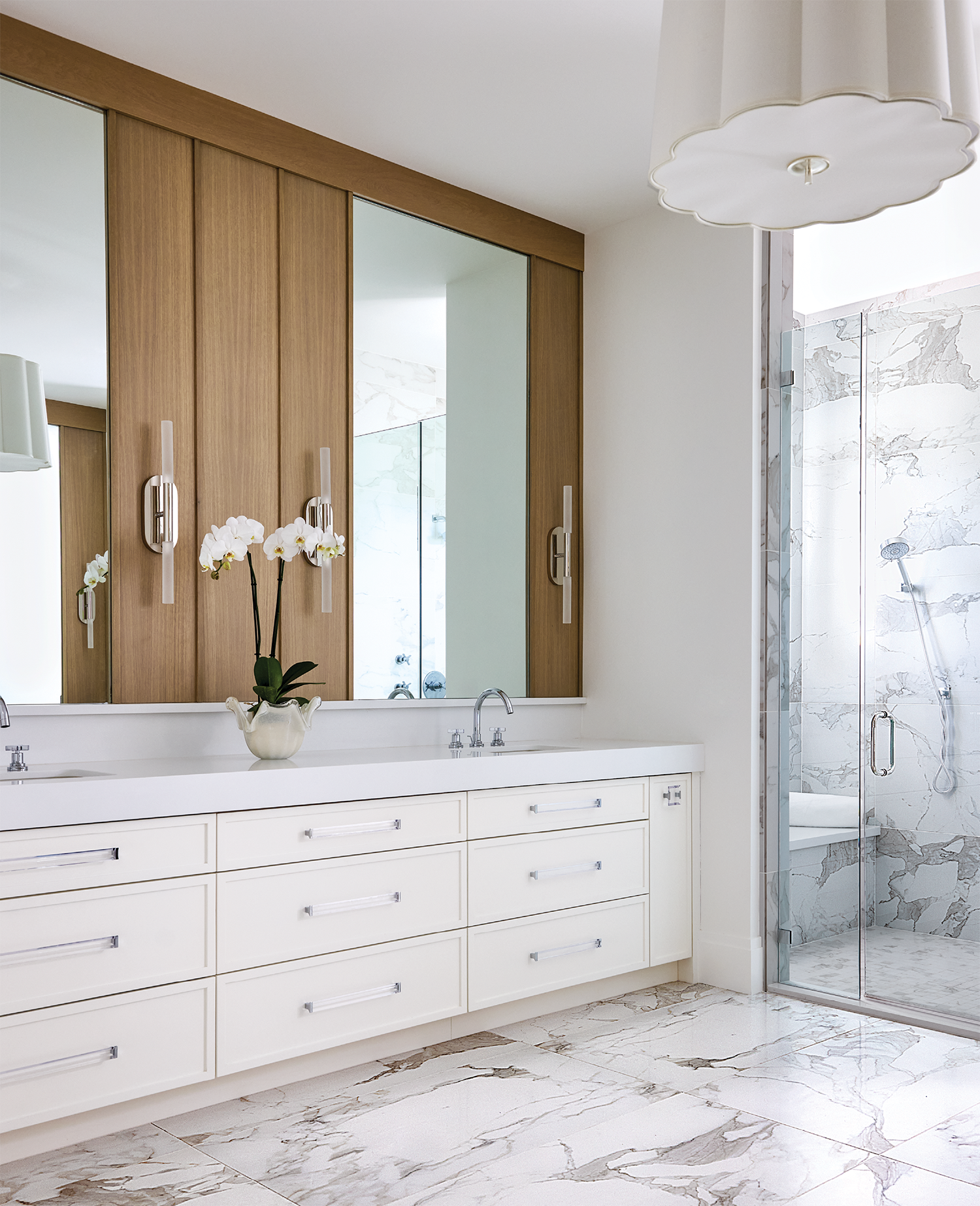 white oak panels line one wall of a white modern primary bathroom