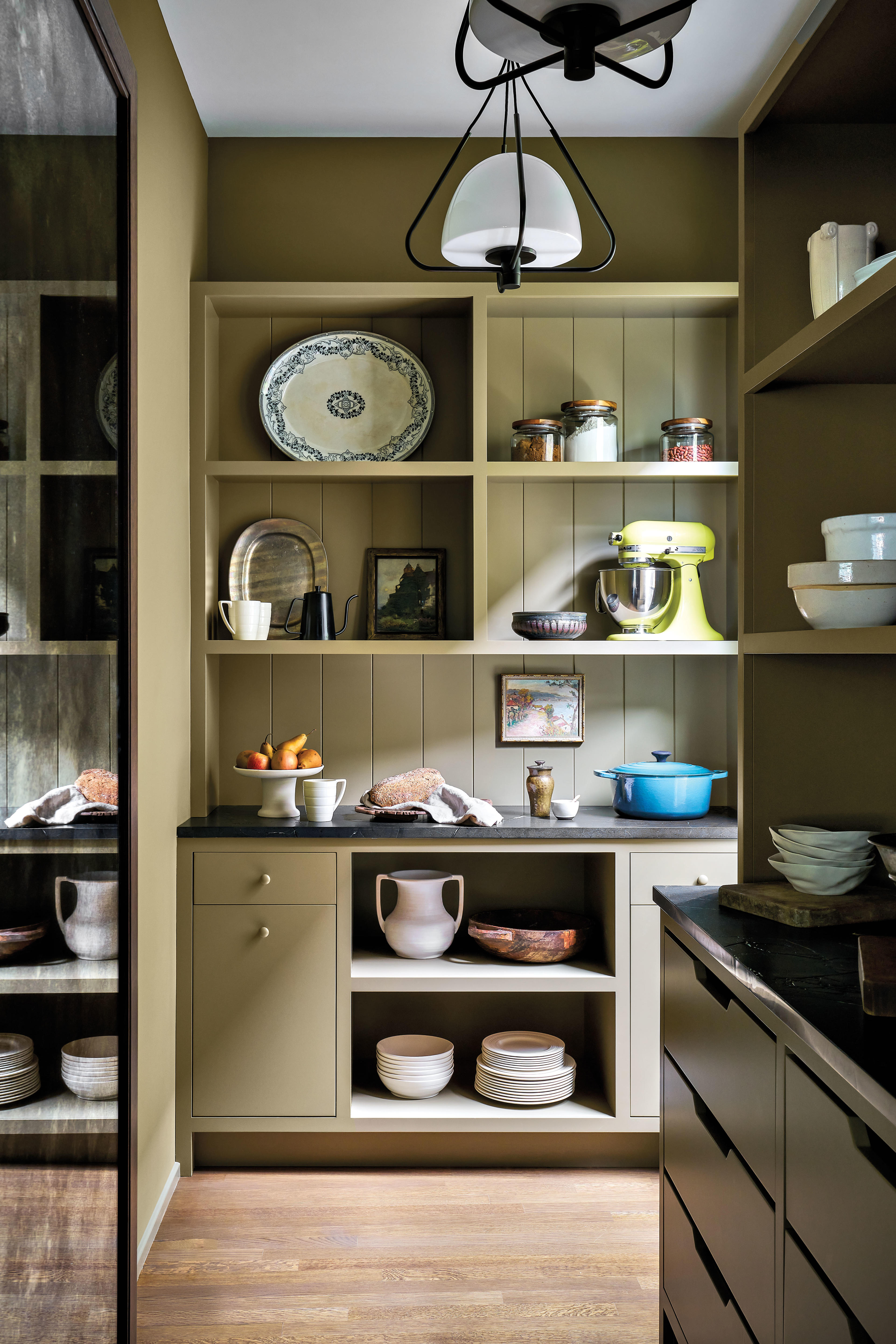 green pantry styled with period homewares and a bright green Kitchen-Aid mixer