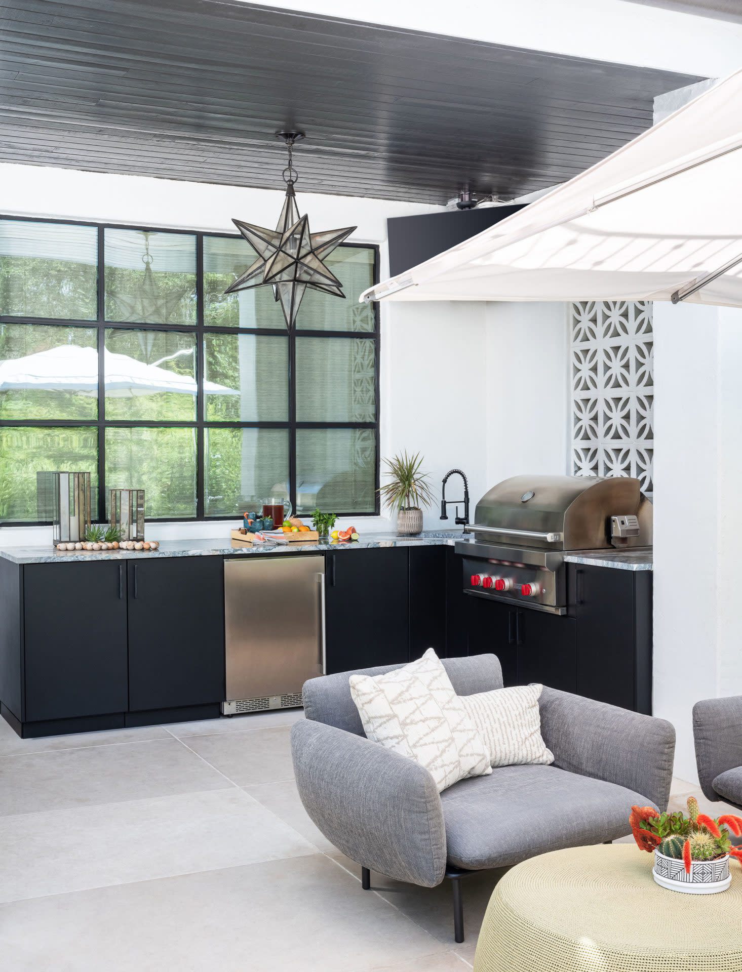 A spacious outdoor kitchen with a large dining area, perfect for enjoying meals in a contemporary setting.
