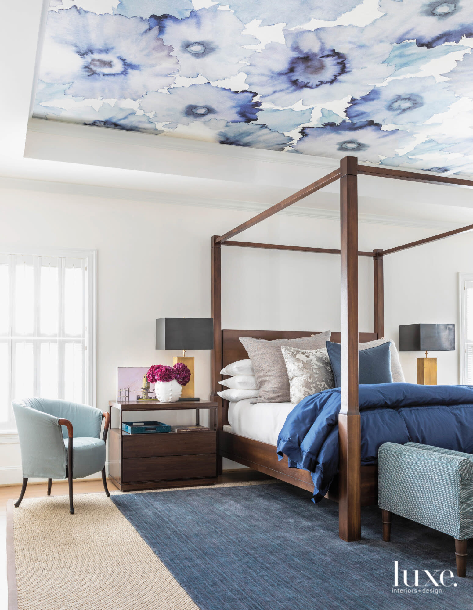 Blue-hued master bedroom with wallpapered ceiling and wooden finishes