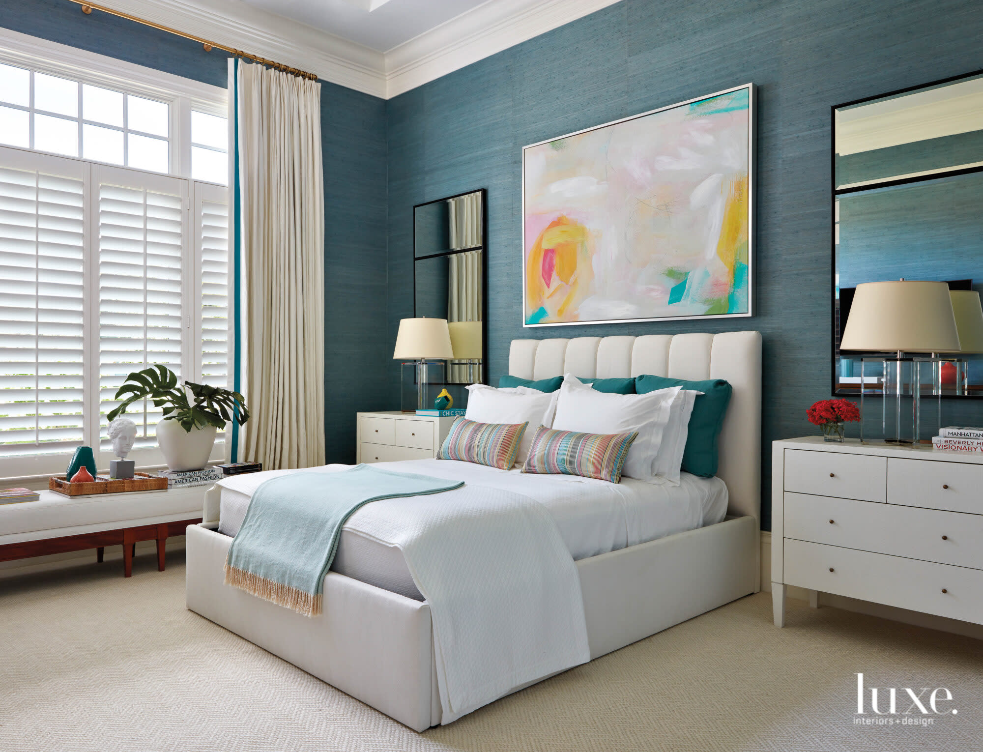 Bedroom with aqua wallcovering and upholstered bed.