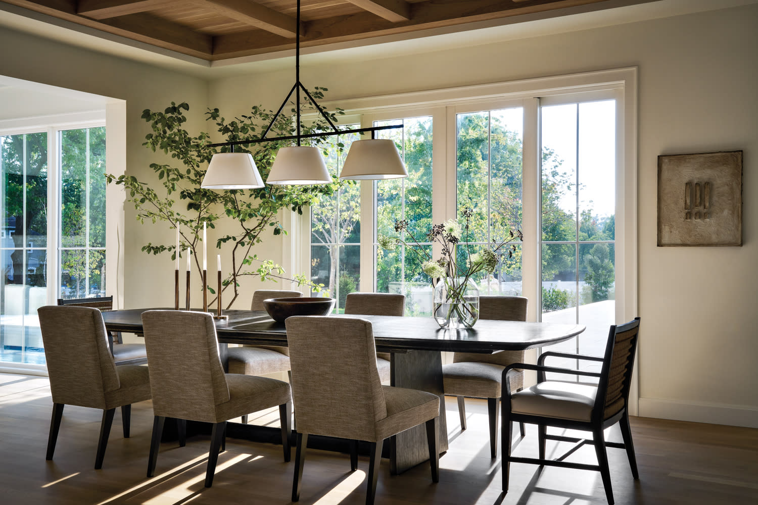 A dining room featuring a wooden table surrounded by four chairs, with soft lighting and a warm atmosphere.
