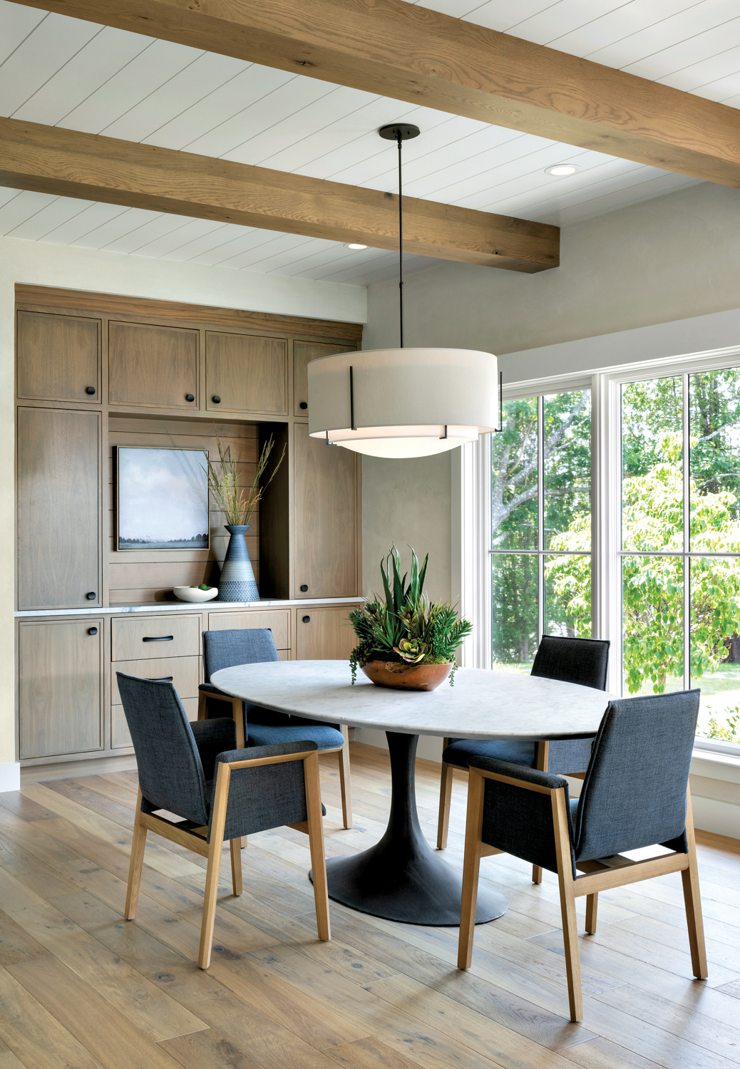 dining room with table, blue chairs, windows