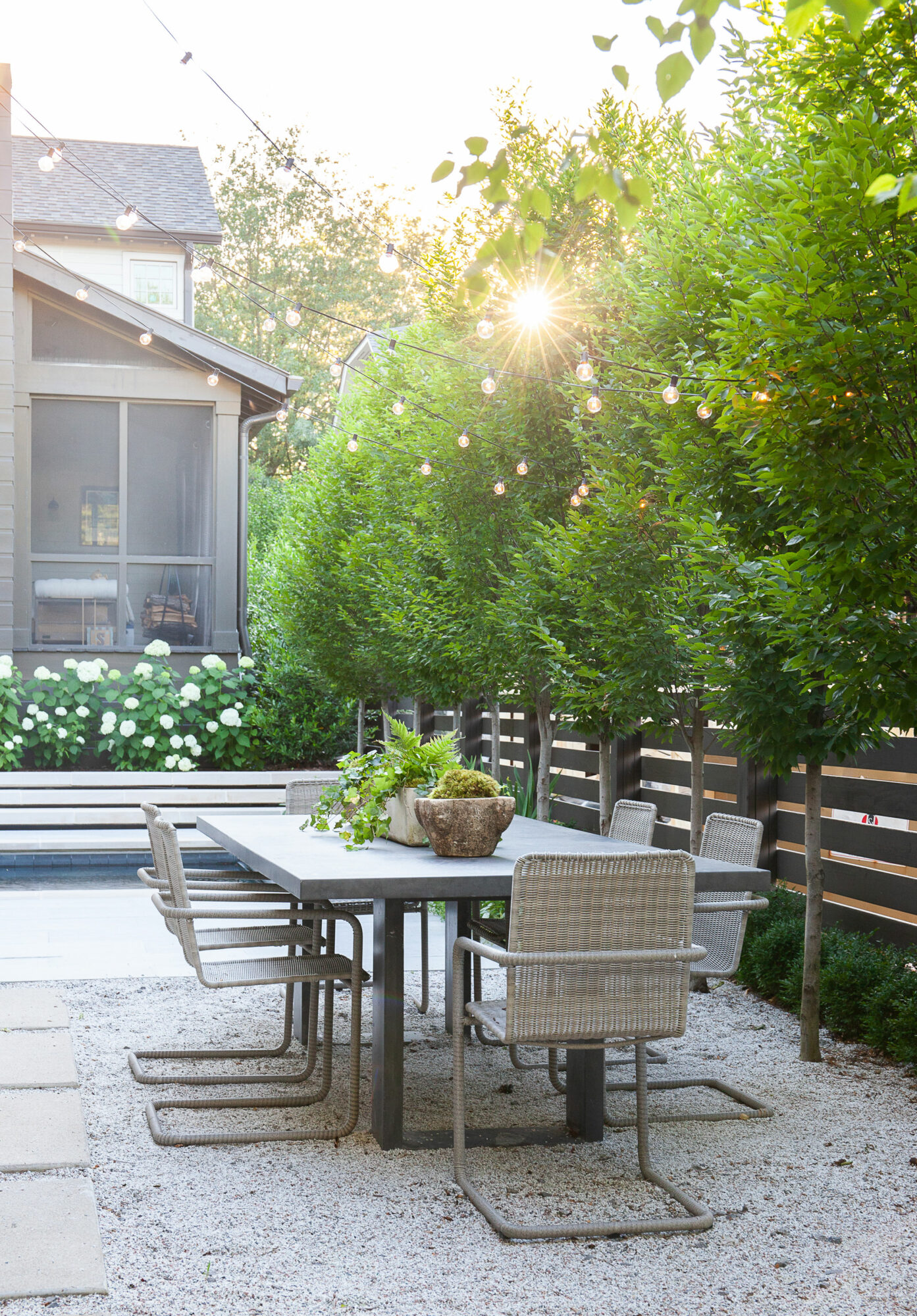 A festive outdoor entertaining area featuring a table tennis table with dining chairs