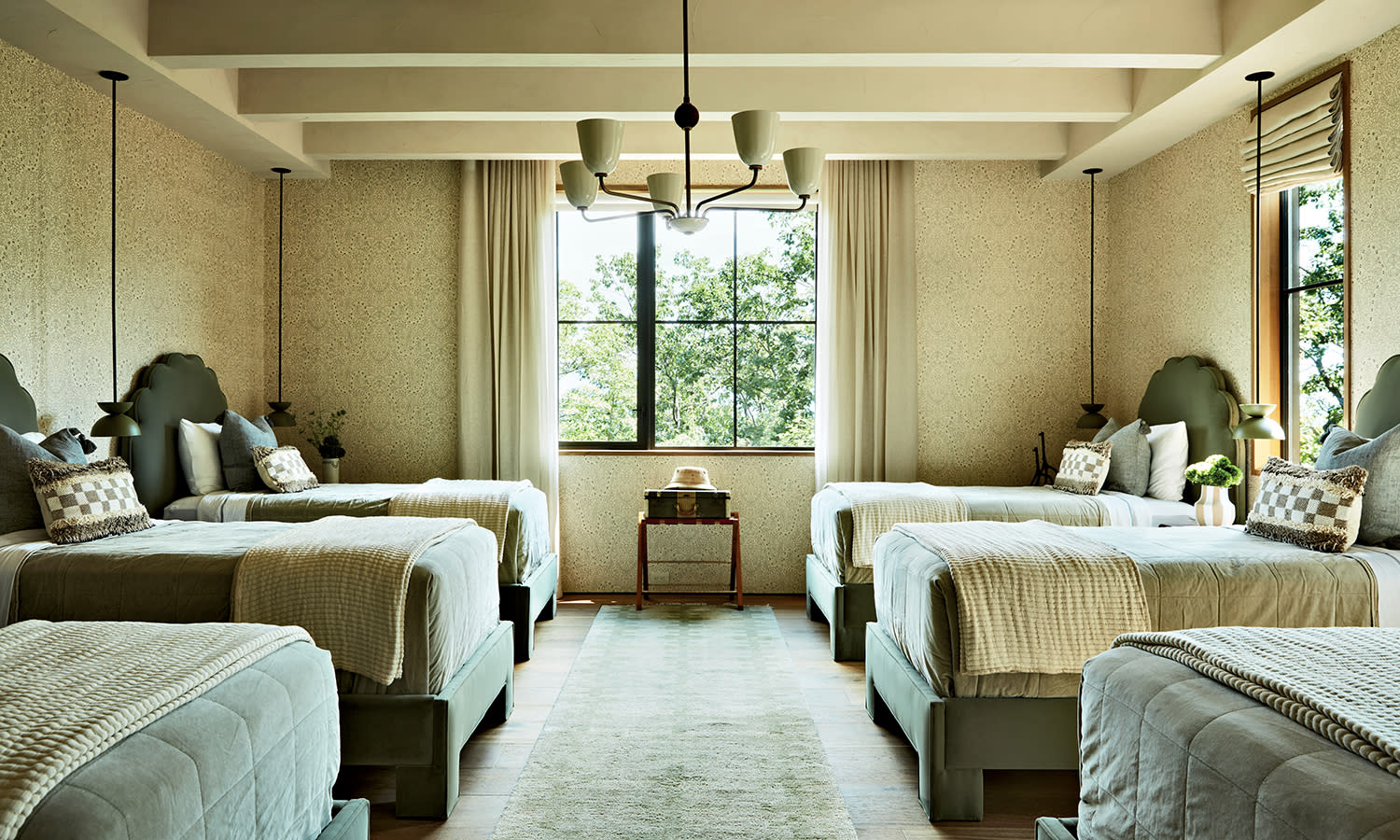 A bedroom with three beds on one wall and another set of three matching beds facing it on the other