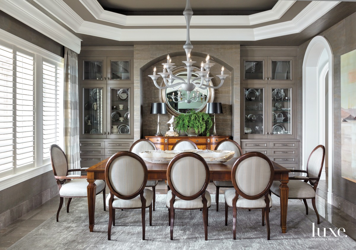 A set of Kravet's Marseilles chairs surround the owners' heirloom table in the dining room. "They have had it since their children were young," Watts says. "It has shared many special moments over the years with their family." The piece is lit by a custom Seguso two-tier chandelier.
