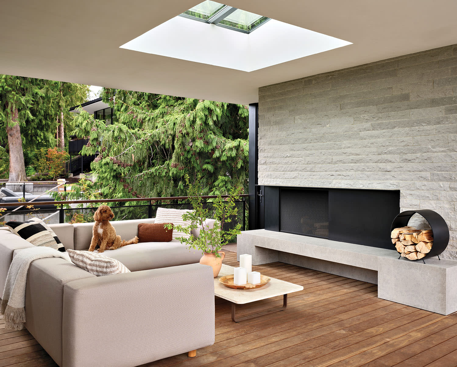 modern deck with a limestone fireplace and a sectional 