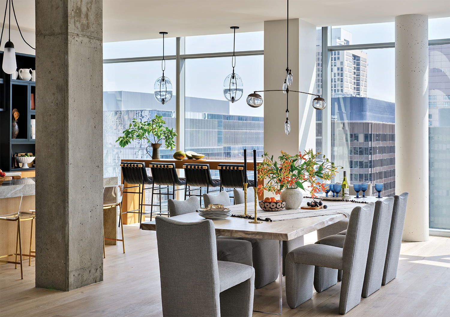 open concept dining room with gray tall chairs around a marble table