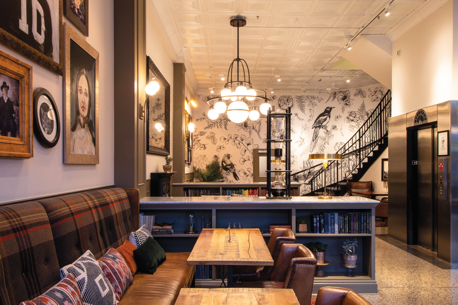 Bar and restaurant area of the Armstong Hotel, with botanical wallpaper and a modern chandelier