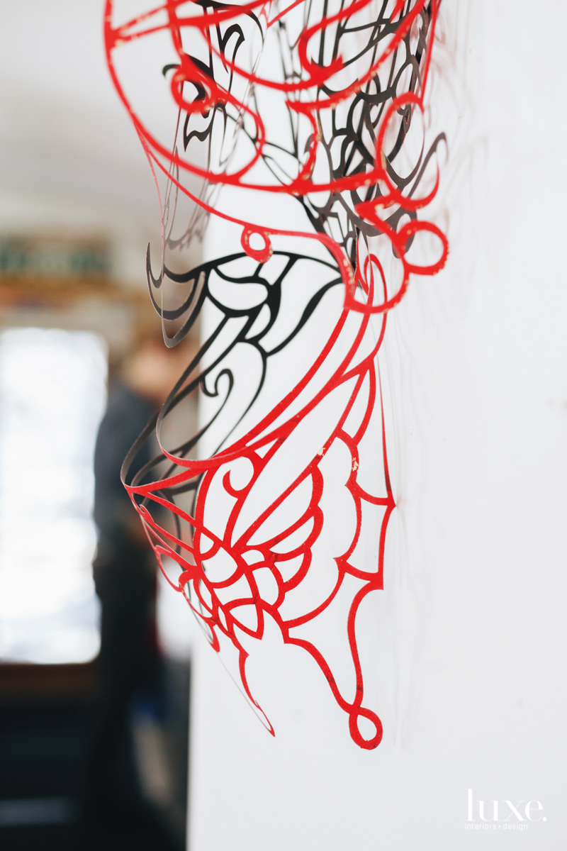 A piece of cut paper dangles in Robert Brinker's studio, before it is applied to canvas.