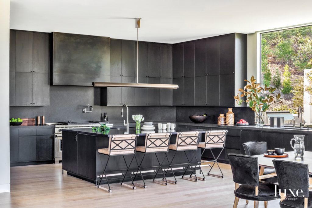 Reina is an avid cook with an arsenal of cooking tools, so the kitchen had to have ample storage along with a clean, kid-friendly aesthetic,&quot; says Hilliard. She designed the black-stained oak cabinets and selected the lava stone island countertop from Sue Fisher King for good looks and durability. The counter stools are by Thomas Hayes Studio, and the pendant light is by Mark Albrecht.