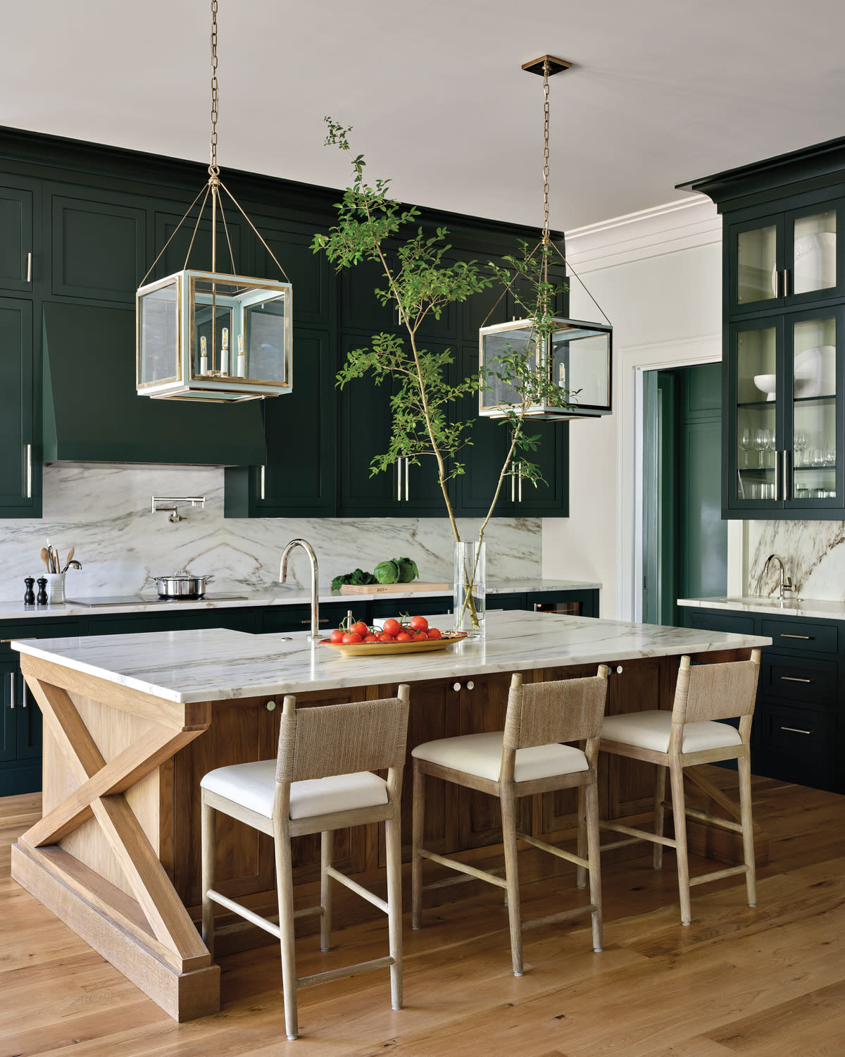traditional kitchen with dark green cabinetry and a marble island