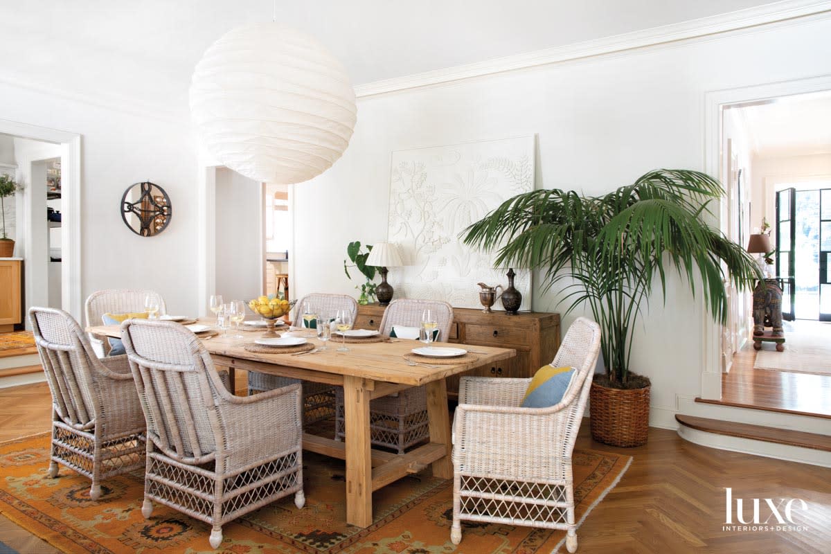 Dining room with wicker chairs, potted palm and oversize paper lantern