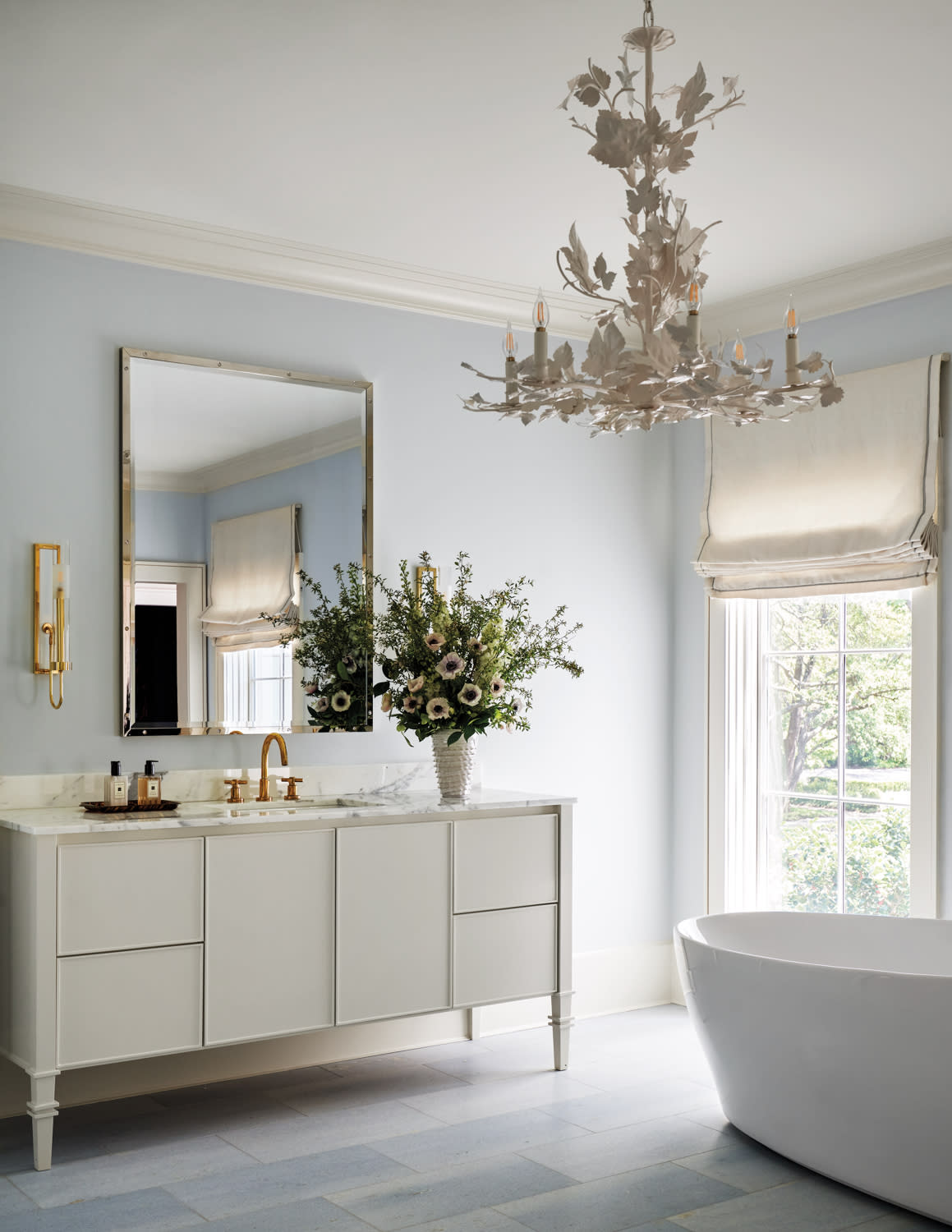 serene bathroom with a neutral color palette and statement chandelier