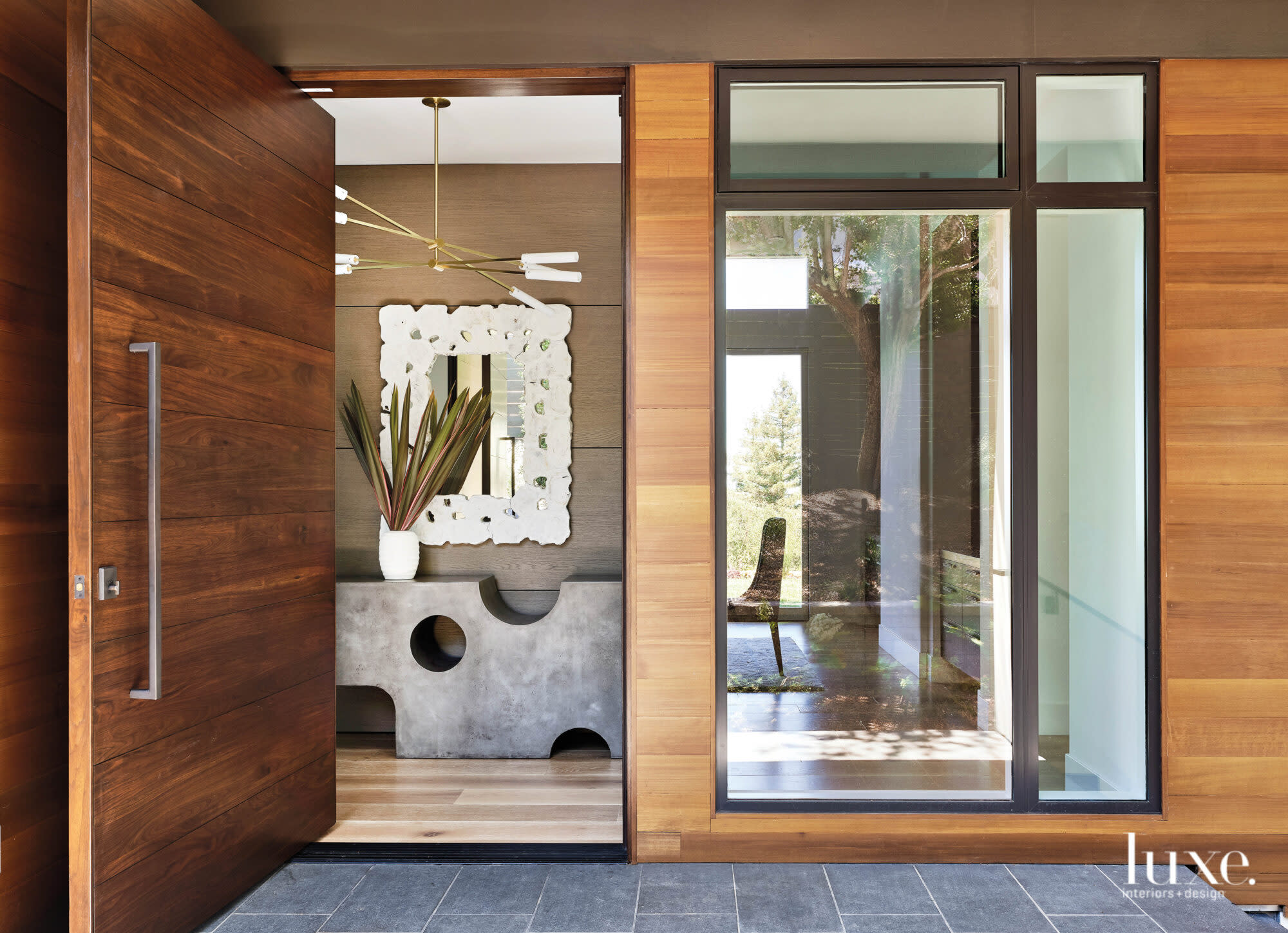 Through a large front door, you can see a large console and mirror.