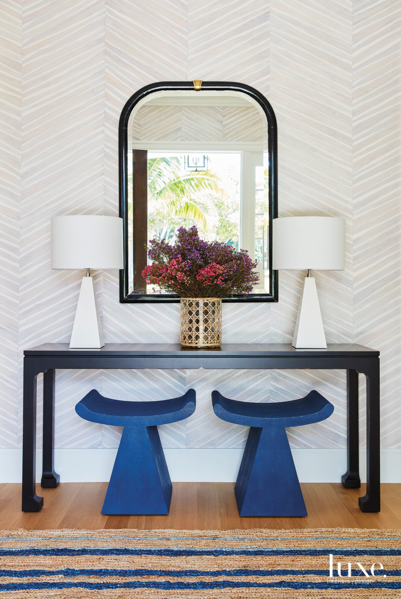 Foyer with blue stools underneath a console table and mirror.