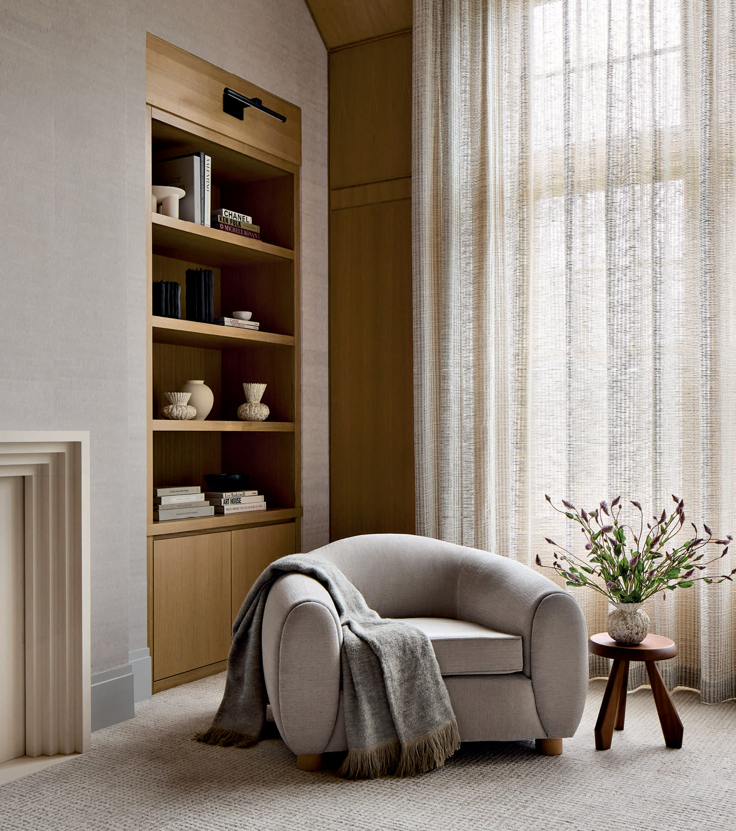 bedroom suite with a gray armchair and a niched shelf featuring trinkets