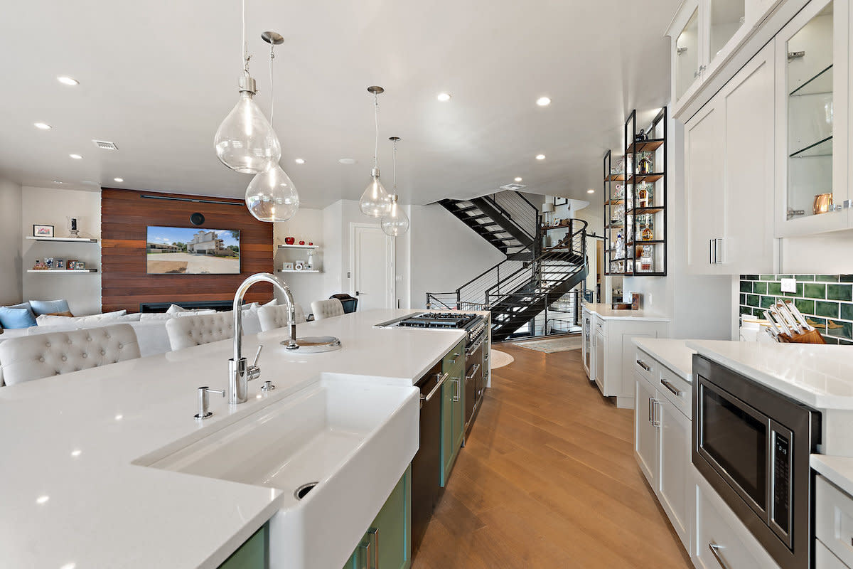 Interior of a kitchen with sink, stove, and staircase.