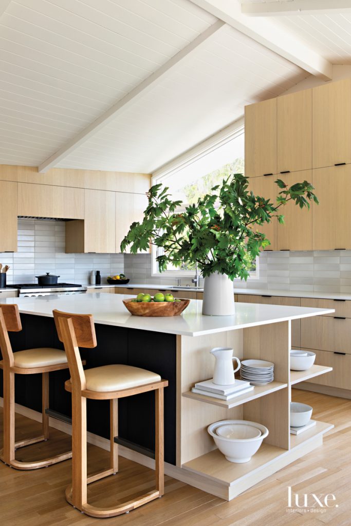 The open kitchen continues the modern spirit of the main living areas and features cabinets by Ziething, Emtek hardware and Caesarstone countertops. The backsplash tiles are by Heath Ceramics; the counter stools are from Nickey Kehoe. "The house has strong character," says Laidlaw. "We didn't want to lose that but build on it.