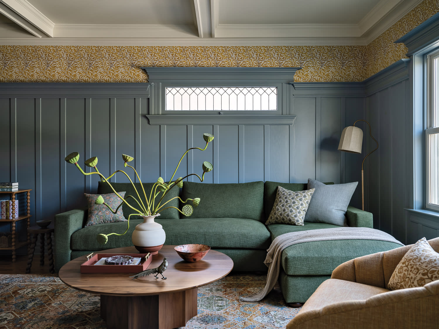 vintage-inspired family room with blue wainscoting and a green sofa