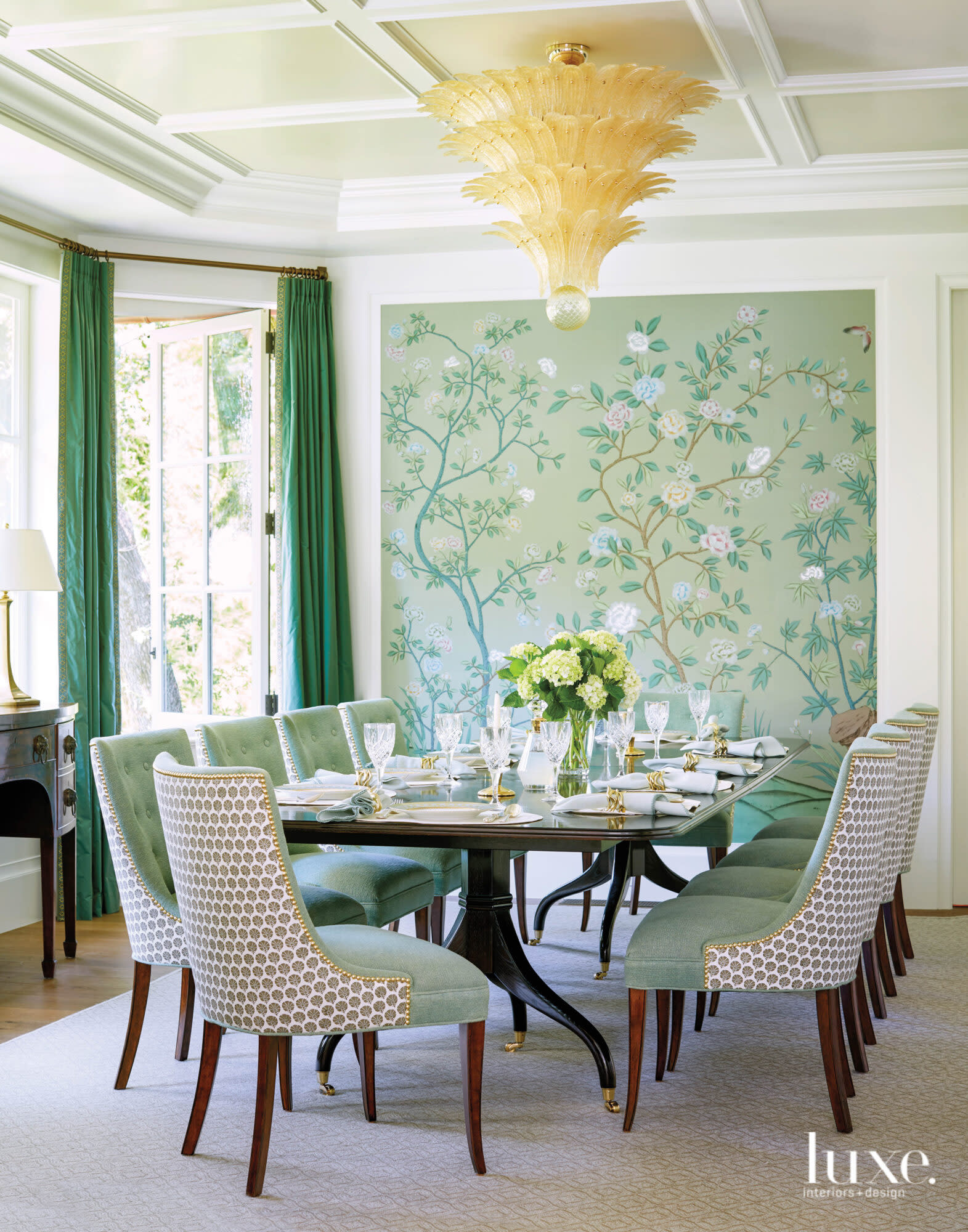 A dining room has a richly patterned wallcovering.