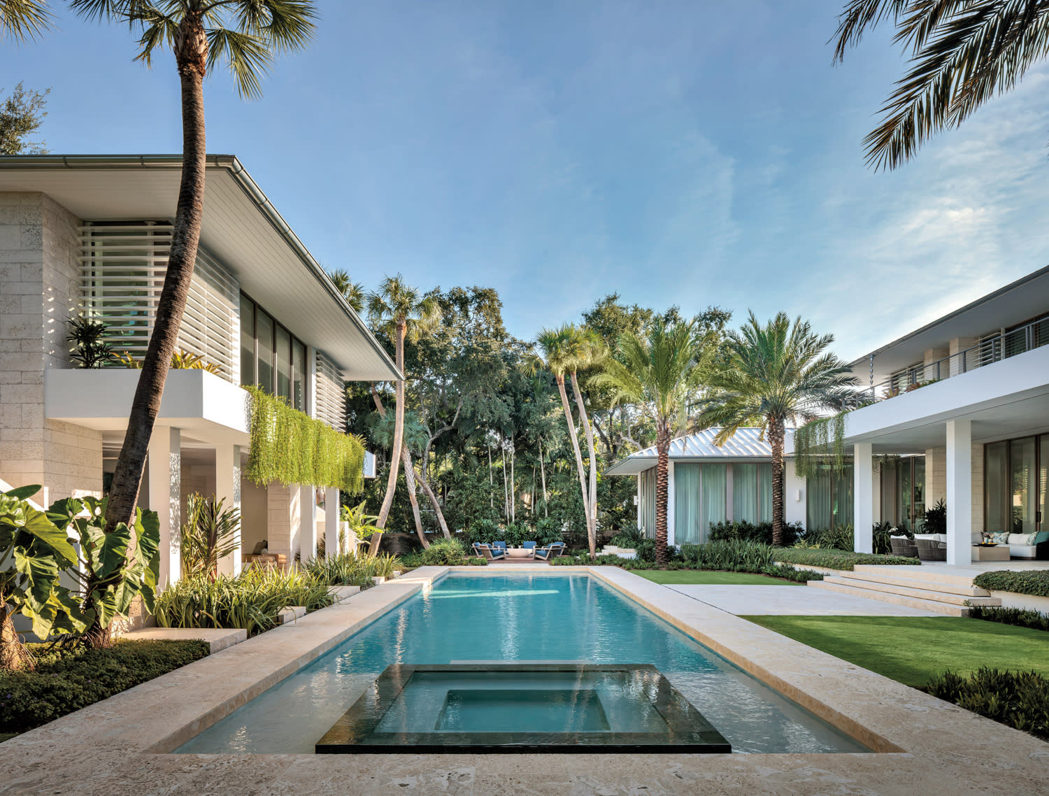 pool flanked by a home's coral stone exterior in Miami