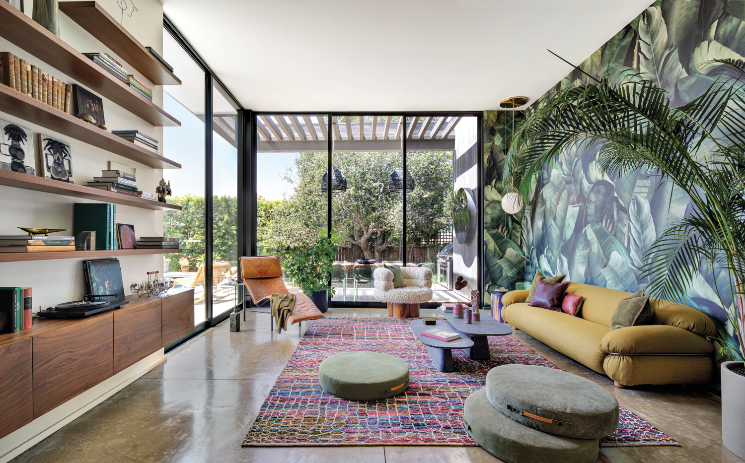 sunken den with banana leaf wallpaper, moroccan area rug, yellow sofa, and round floor cushions by Jen Samson