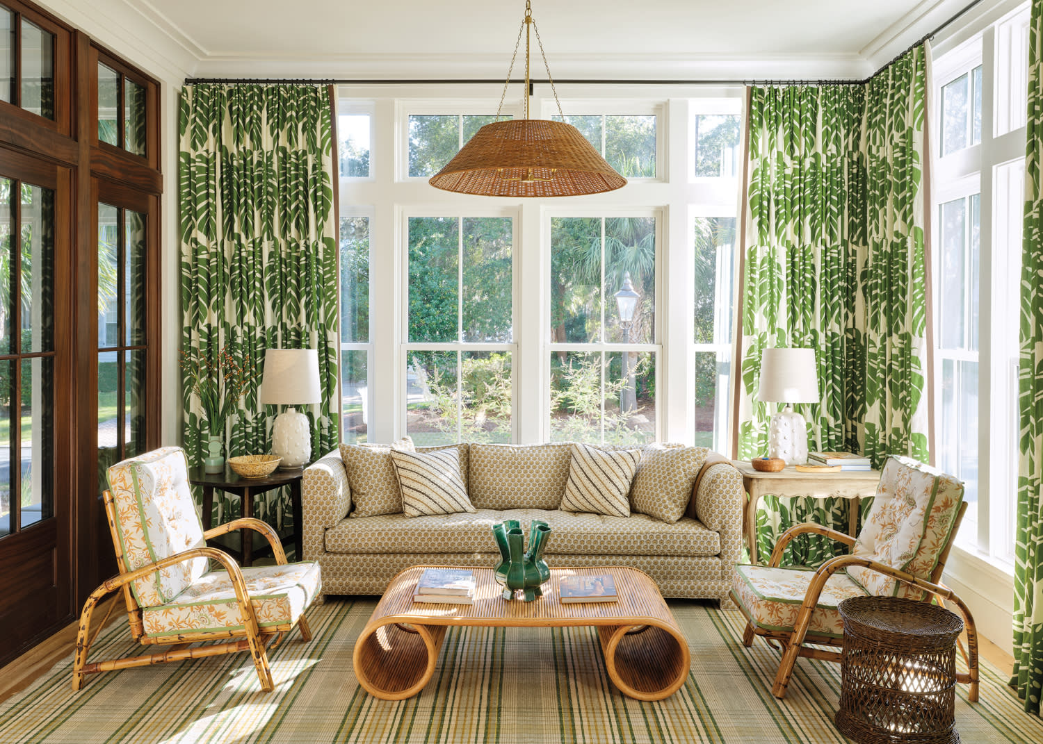palm-leaf print curtains hang in a neutral sun room