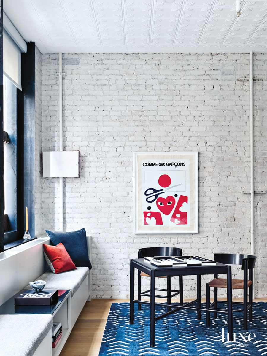 living room with bench under window and blue rug