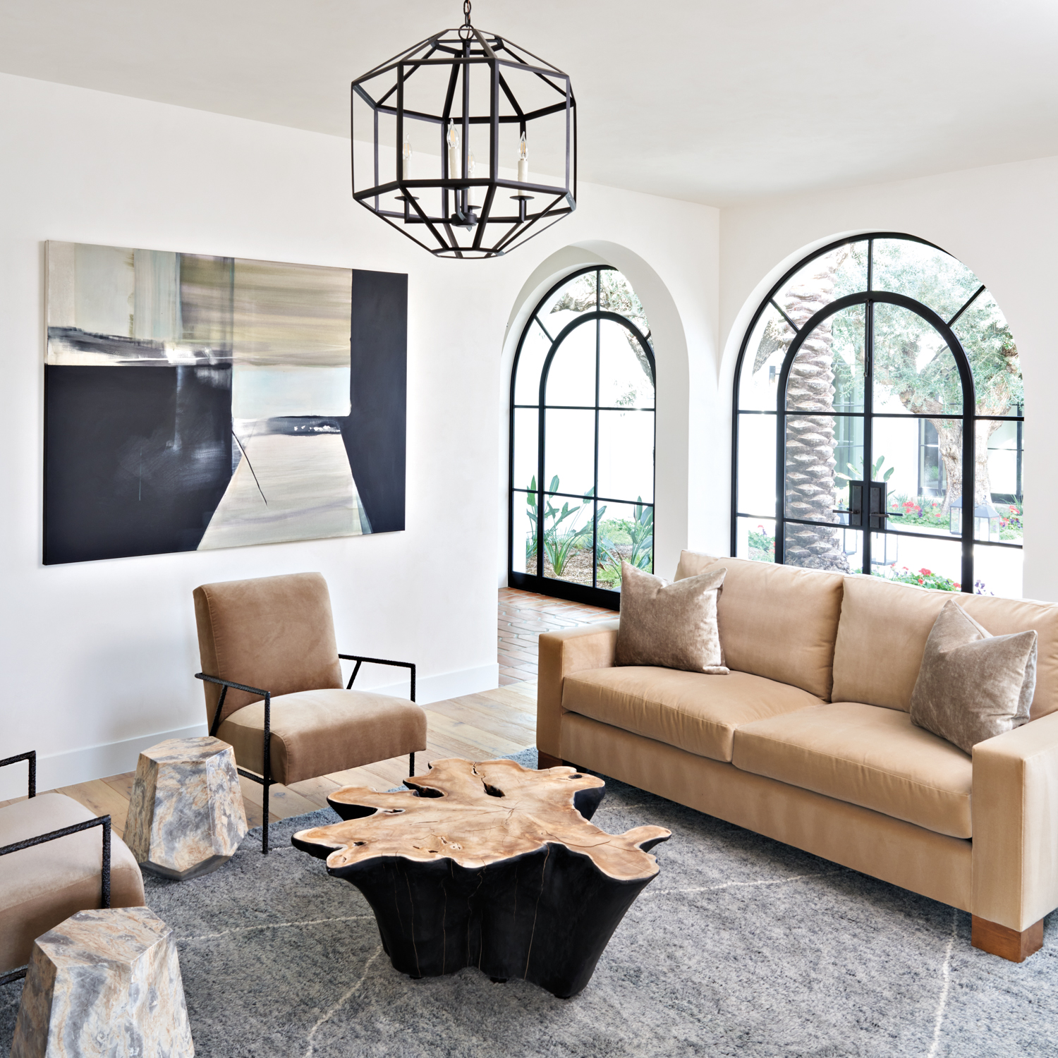 bedroom lounge area with tan sofa and armchairs and live-edge coffee table