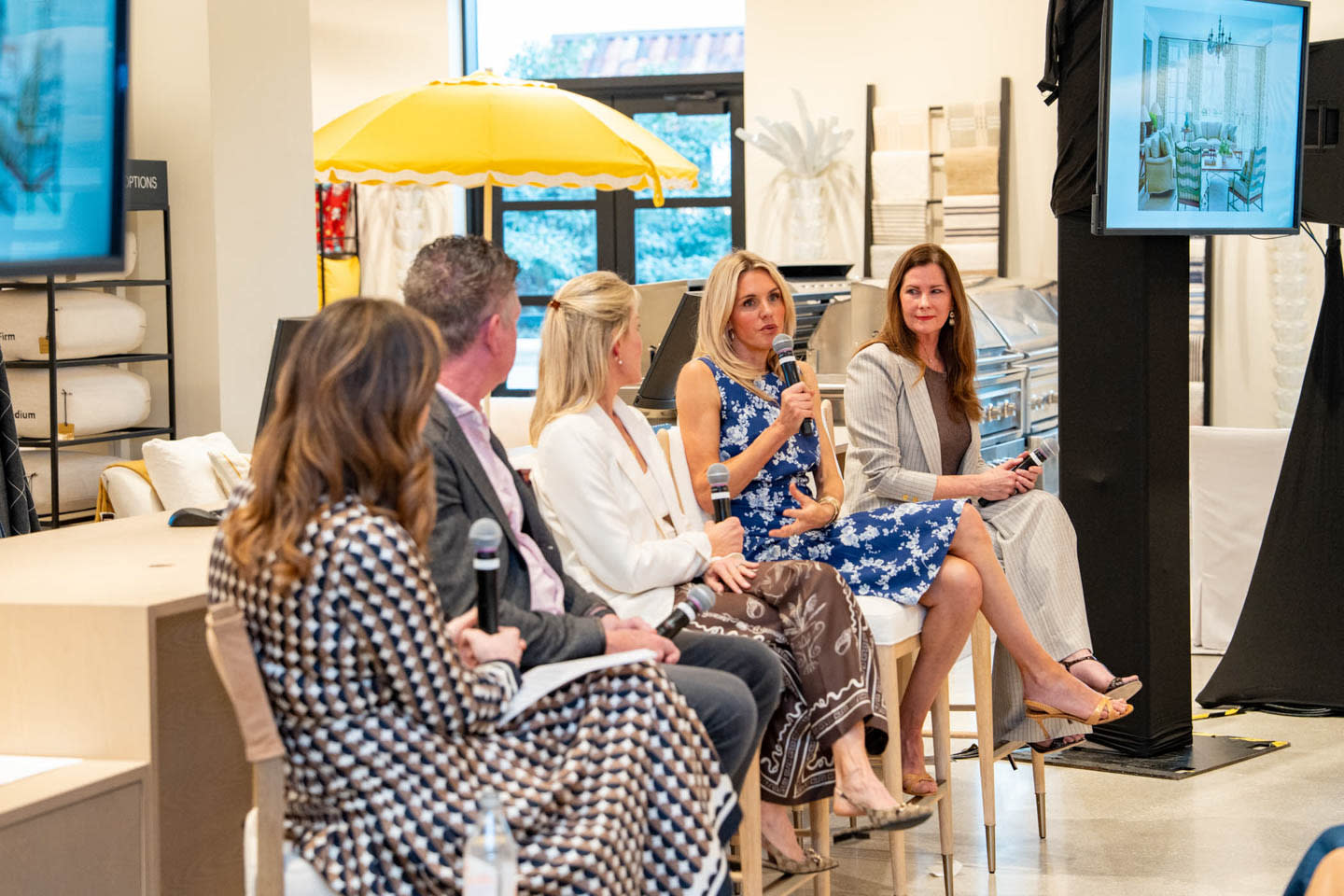 A panel of four people seated indoors, engaged in discussion.