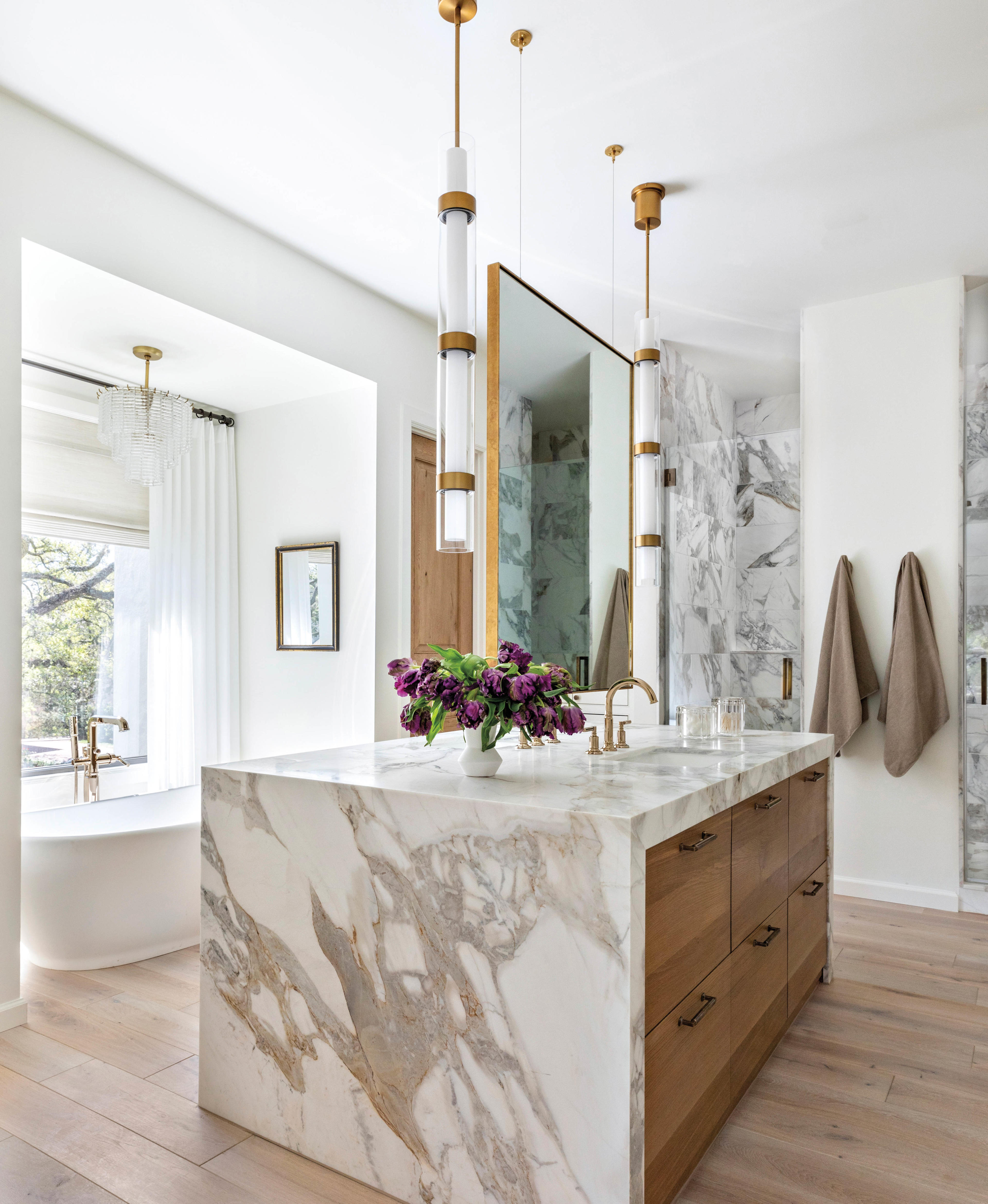 primary bathroom with marble vanity in center with hanging double-sided mirror