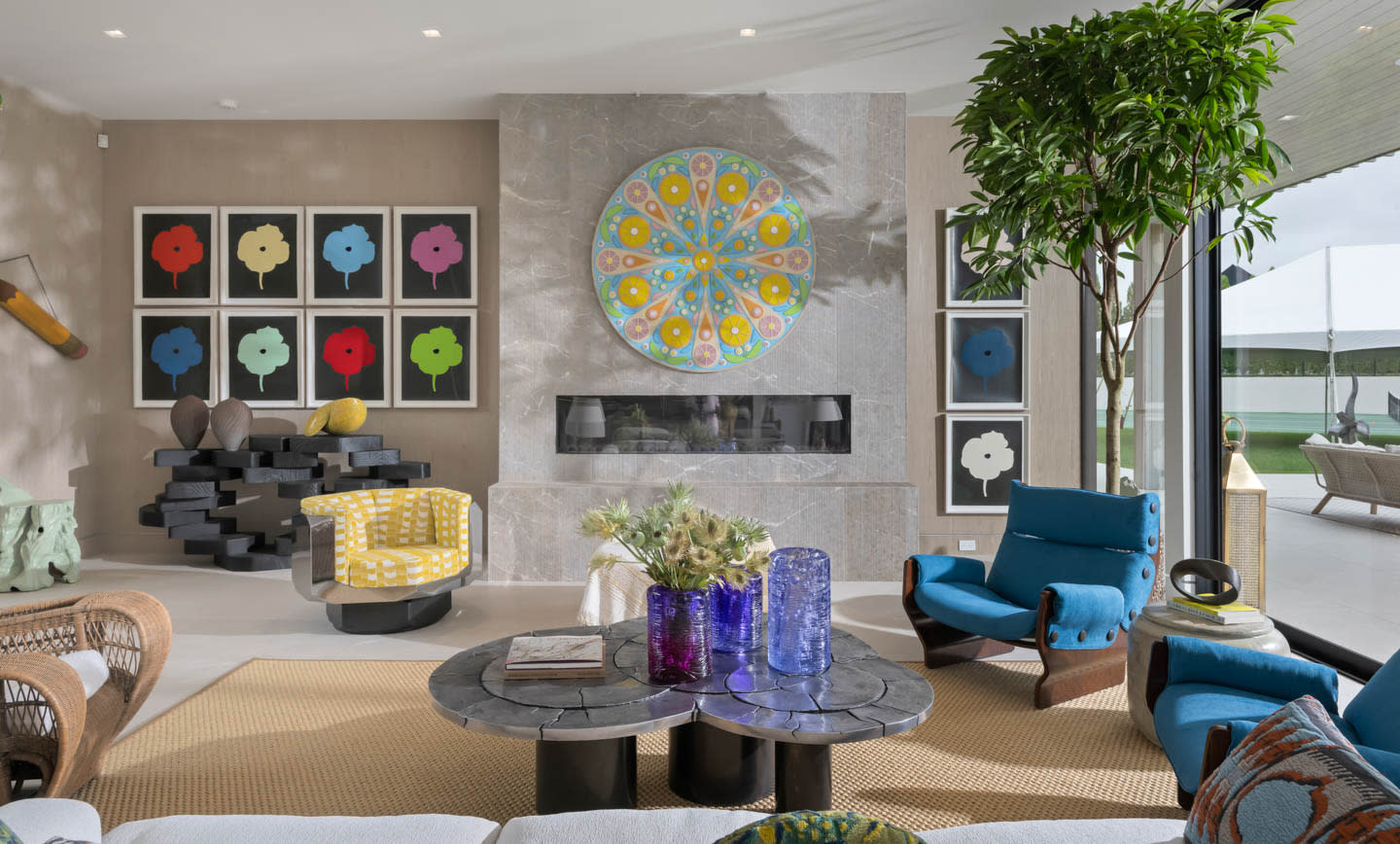 colorful, midcentury-inspired living room with blue armchairs and a series of floral prints