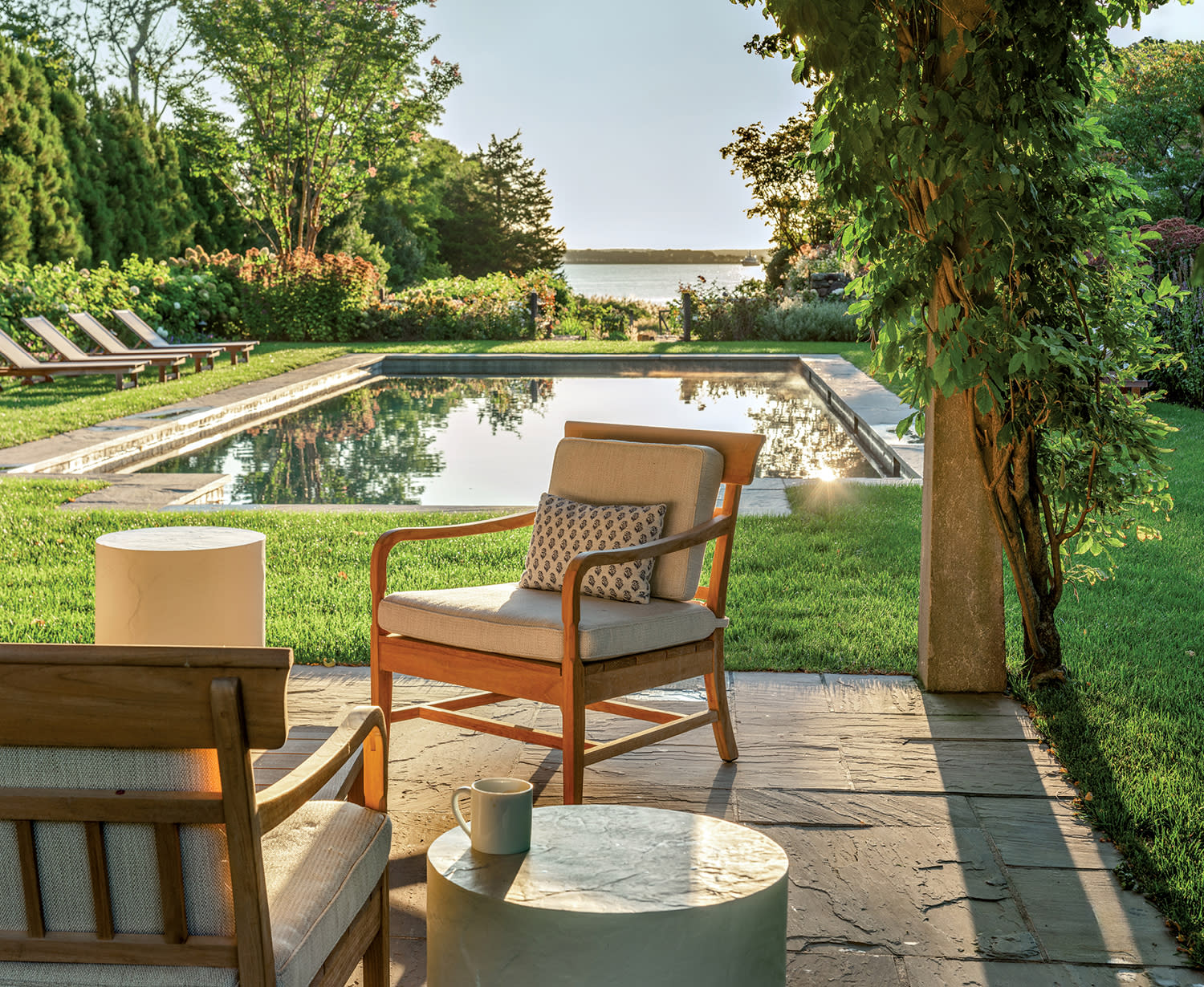 poolside pergola with teak furnishings in the Hamptons