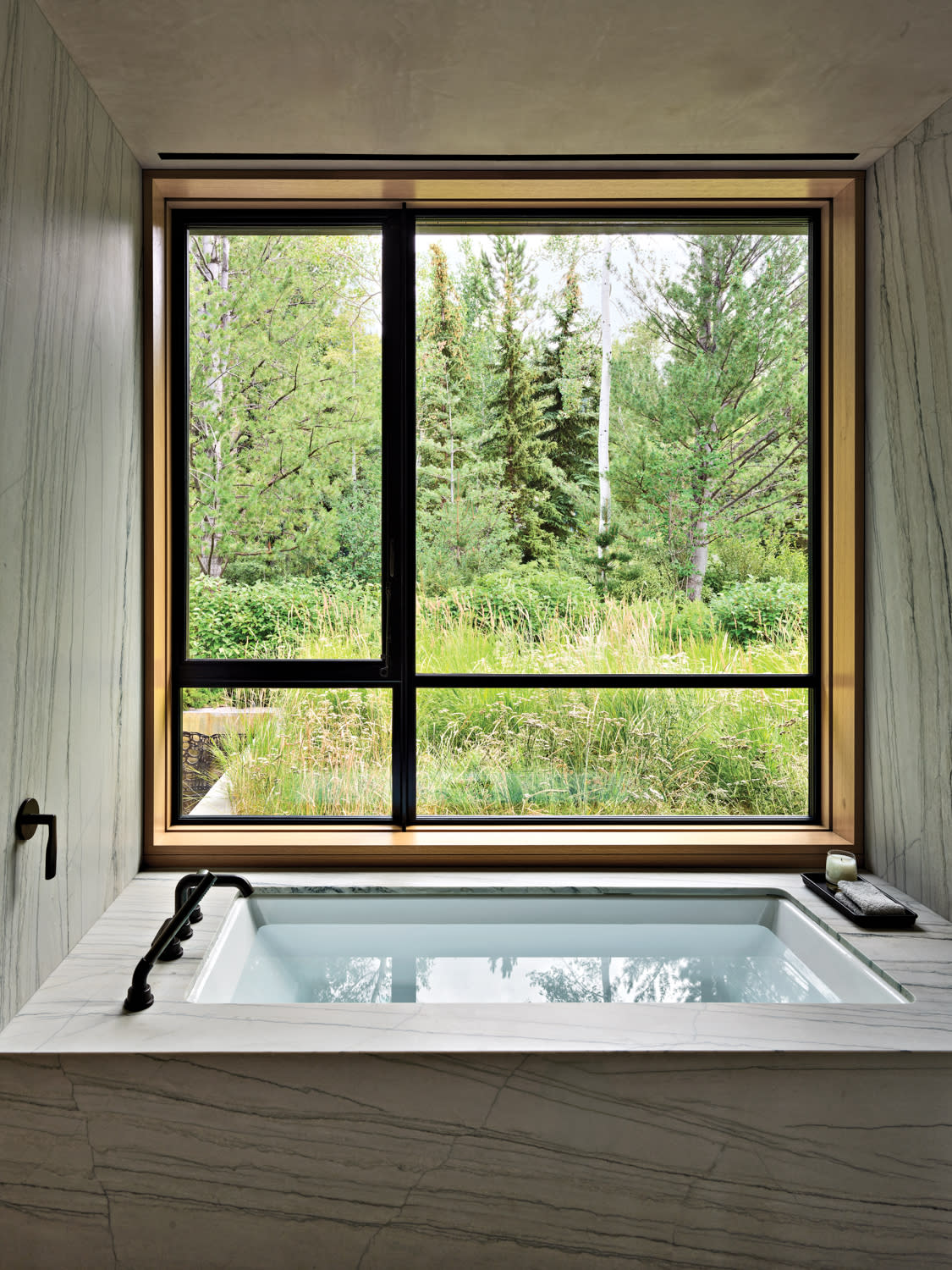 contemporary bathroom with a quartzite-surrounded tub and views of Colorado landscape outside