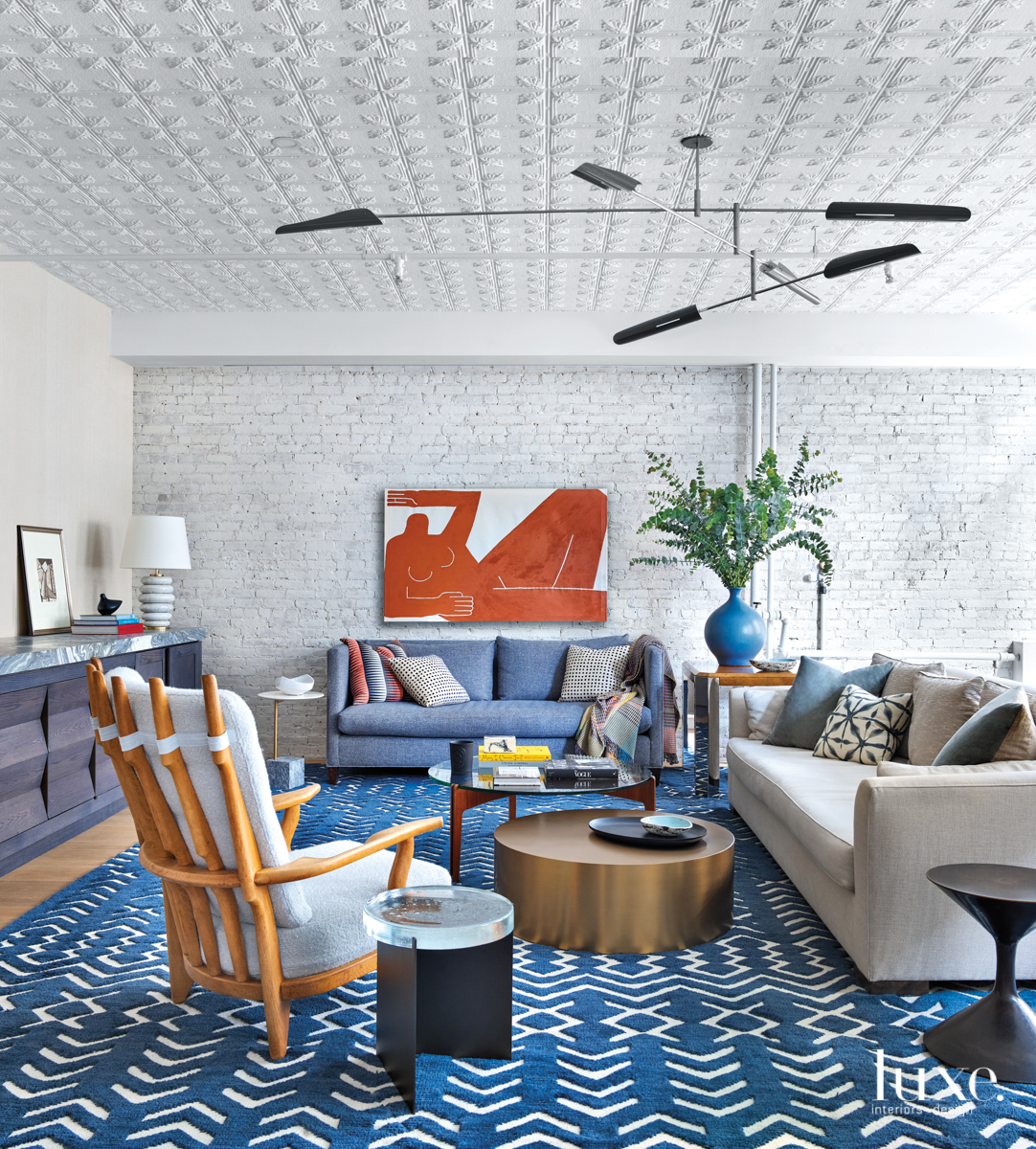 liivng room with textured ceiling, blue rug and orange art