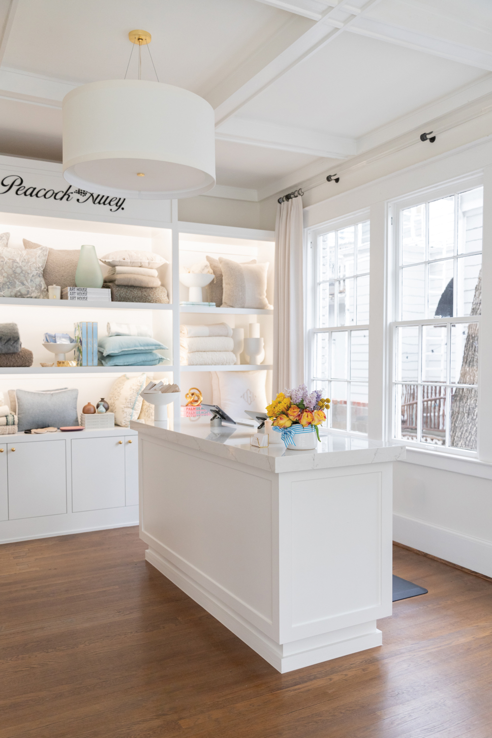 Built-in shelving displaying pillows, linens and home accents next to a showroom information desk