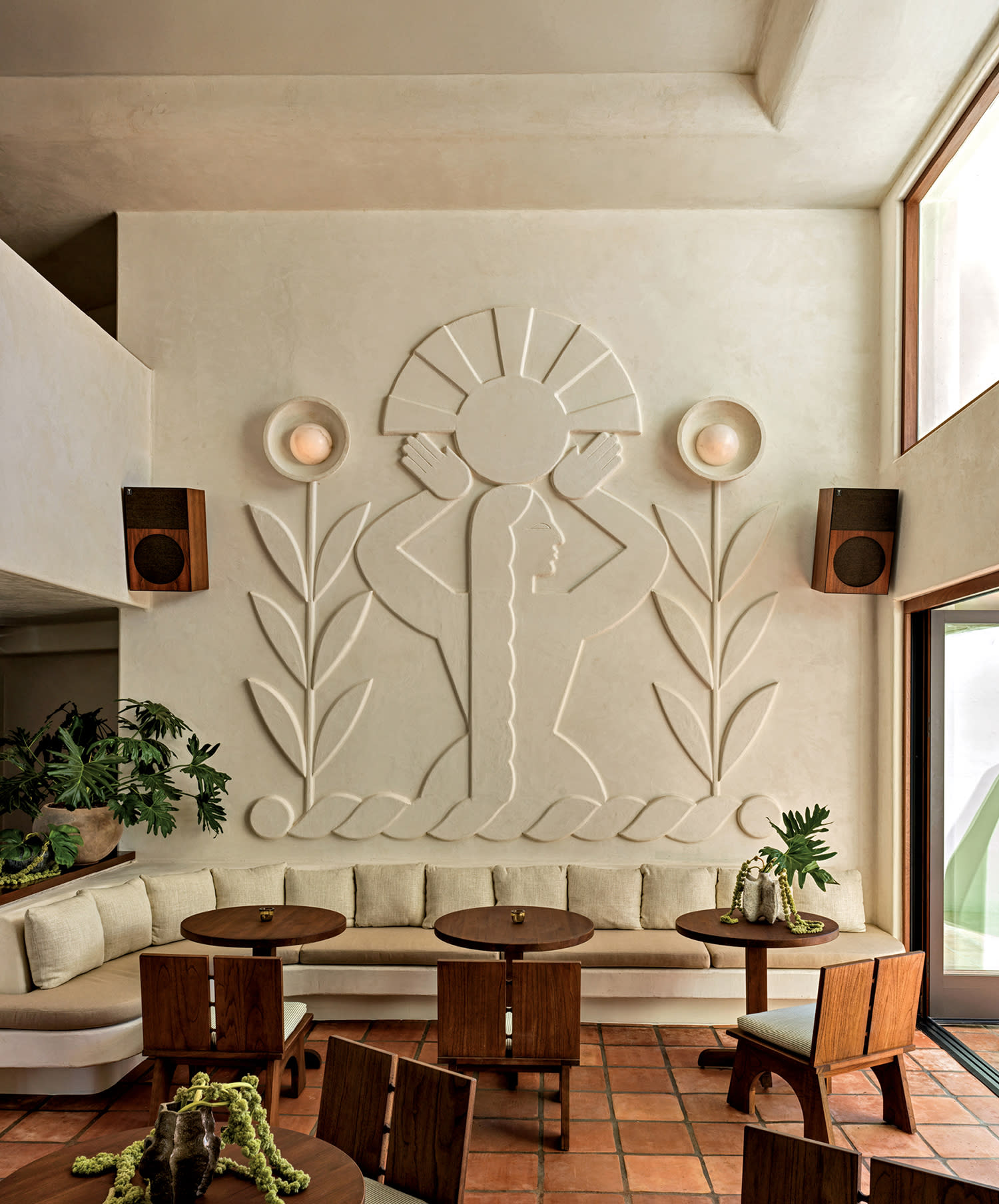 A sculptural mural with floral and geometric relief patterns in a contemporary hotel lobby 