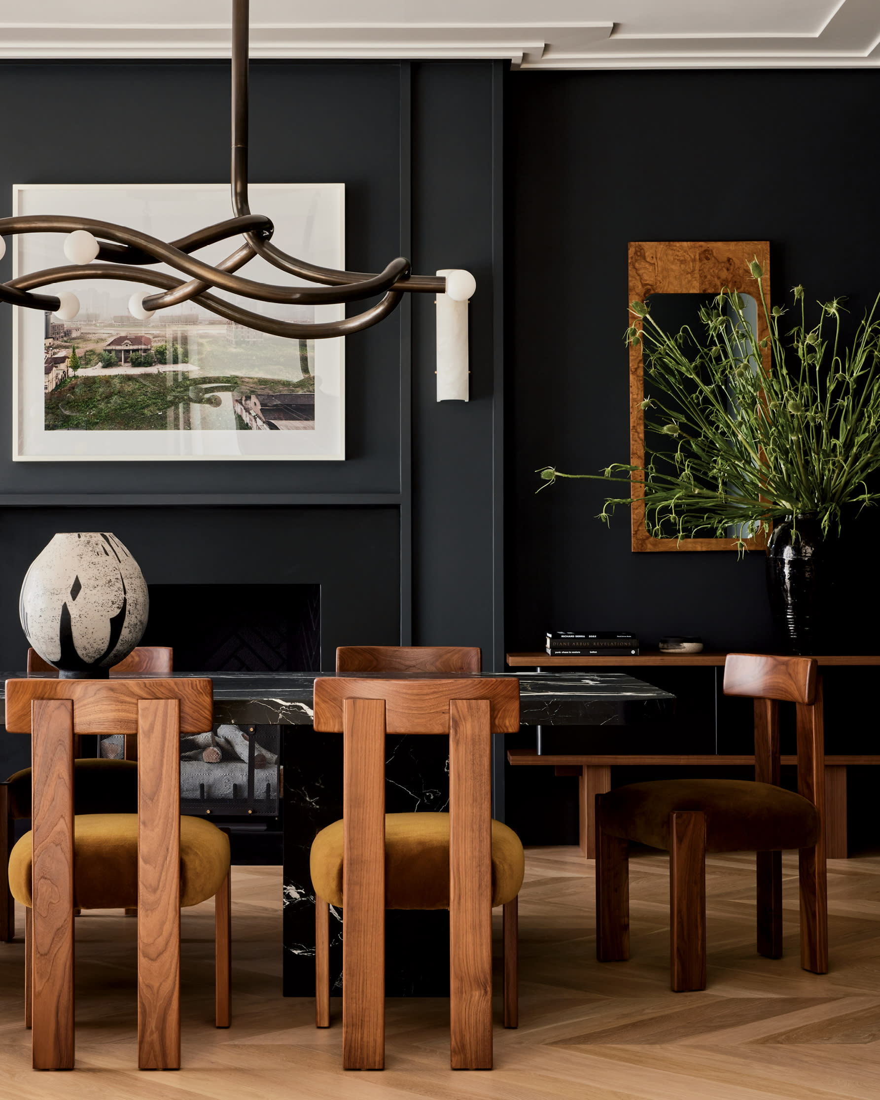 dining room with black walls and midcentury style dining chairs